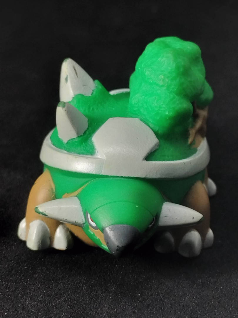 遊戲 桌布 壁紙 — 一隻手繪的綠色和白色塑膠玩具龜，背上有刺和一棵樹，背景為黑色。