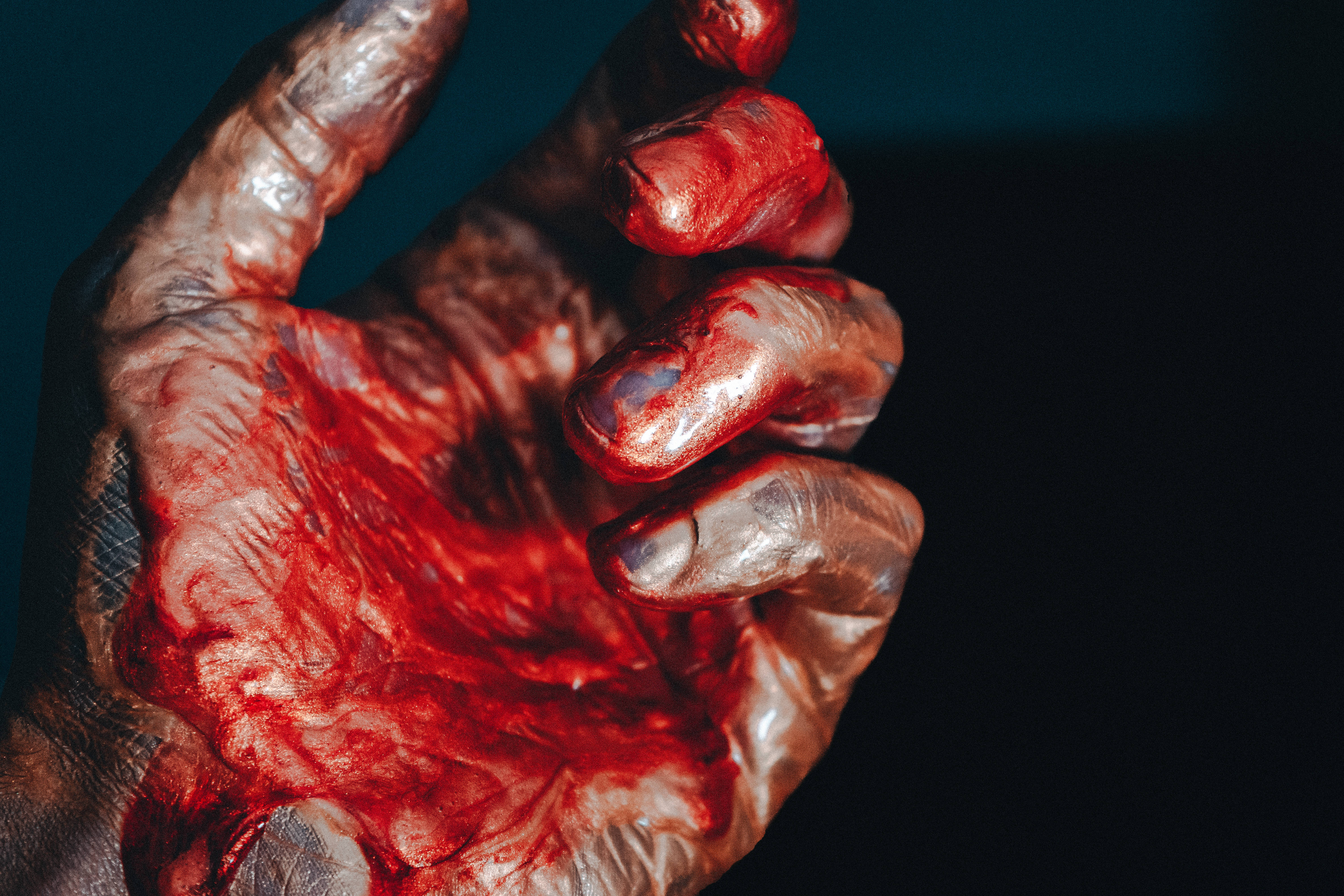 Blood Splatter 桌布 壁紙 — 一隻手被鮮紅色血液覆蓋的特寫，背景為深色。