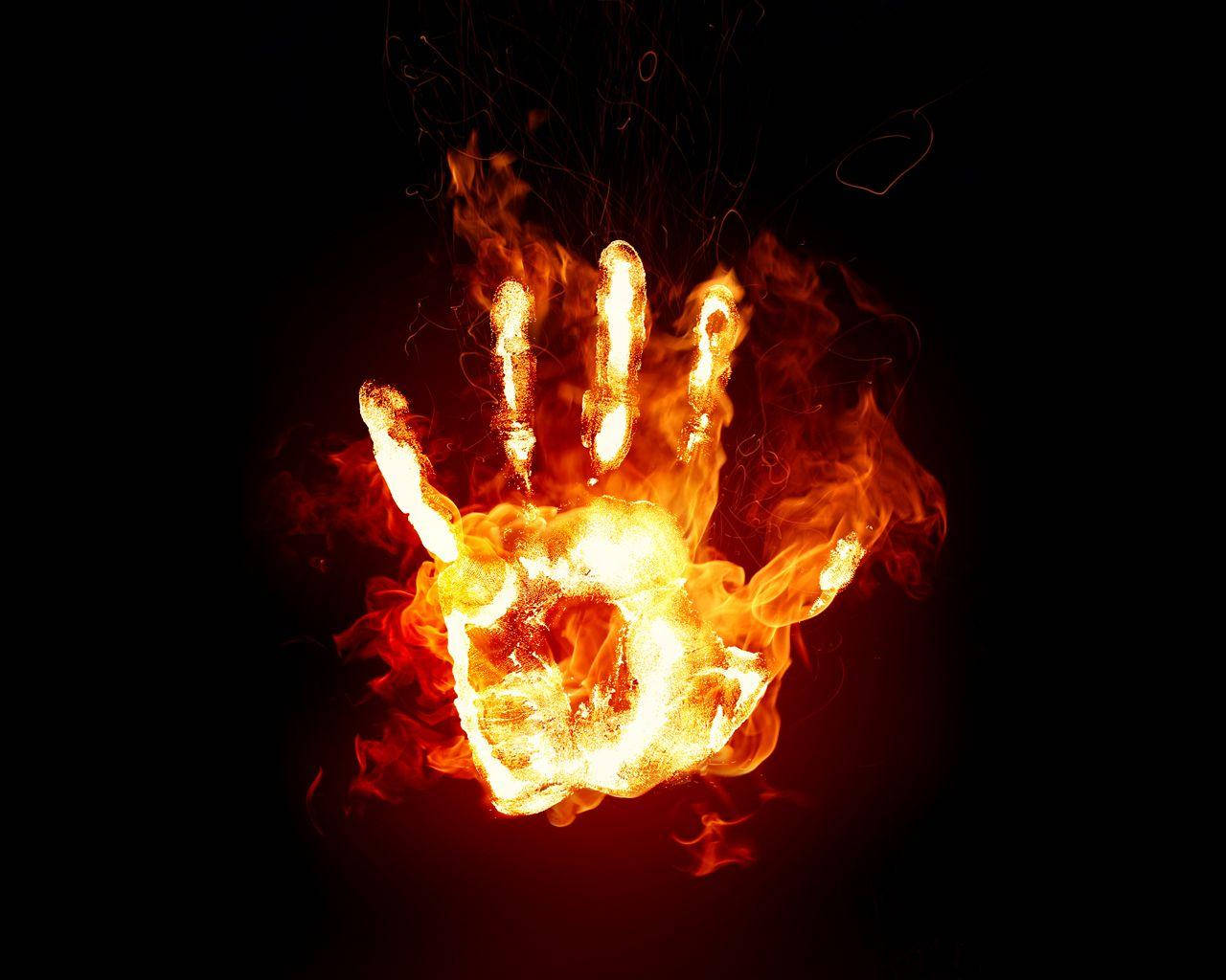 Flame 桌布 壁紙 — 一隻手被鮮豔的橙色和黃色火焰吞噬，背景是純黑色，並有上升的煙霧。