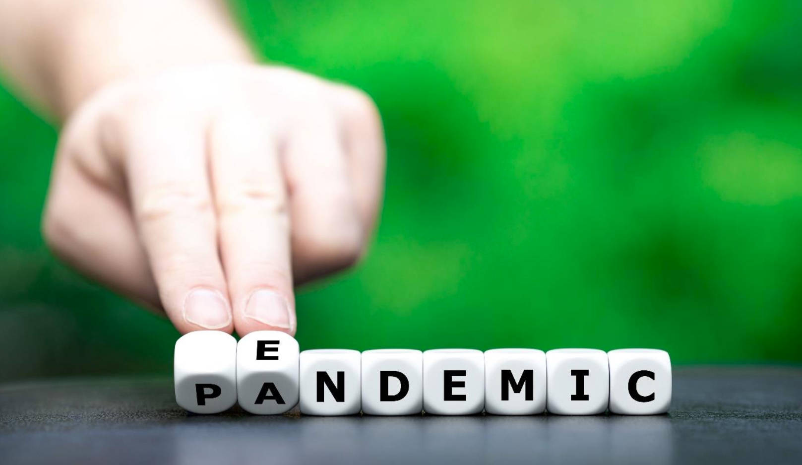 Word 桌布 壁紙 — 一隻手調整一個白色立方體，在模糊的綠色背景上拼出「EPIDEMIC」。