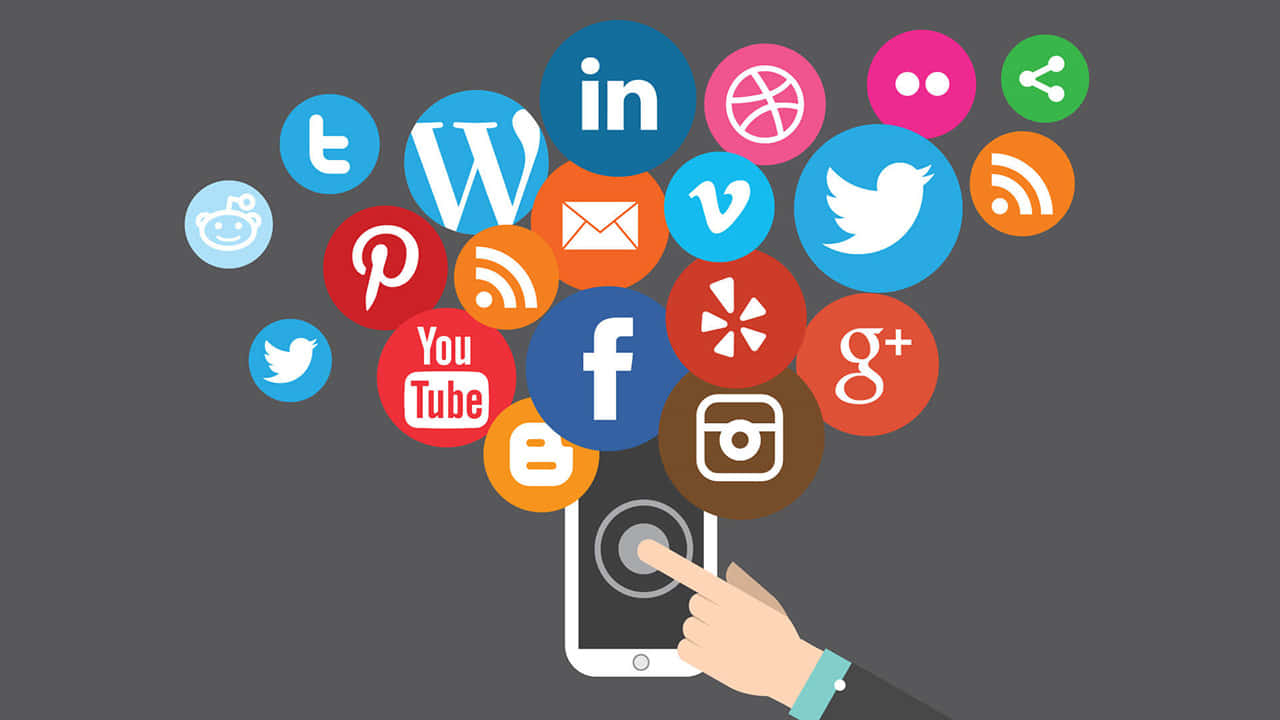 Social Media Logos 桌布 壁紙 — 一隻手輕觸智慧型手機，在灰色背景上釋放出色彩繽紛的社交媒體圖示。