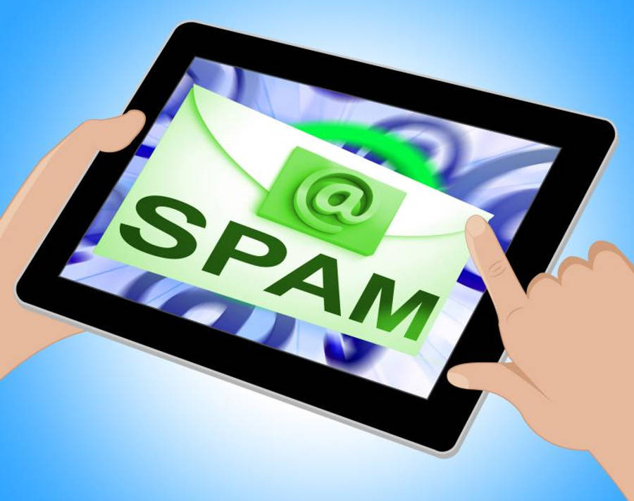 Email 桌布 壁紙 — 一隻手輕點平板電腦，螢幕上顯示一個綠色信封，標有垃圾郵件和@符號，背景是旋轉的藍色。