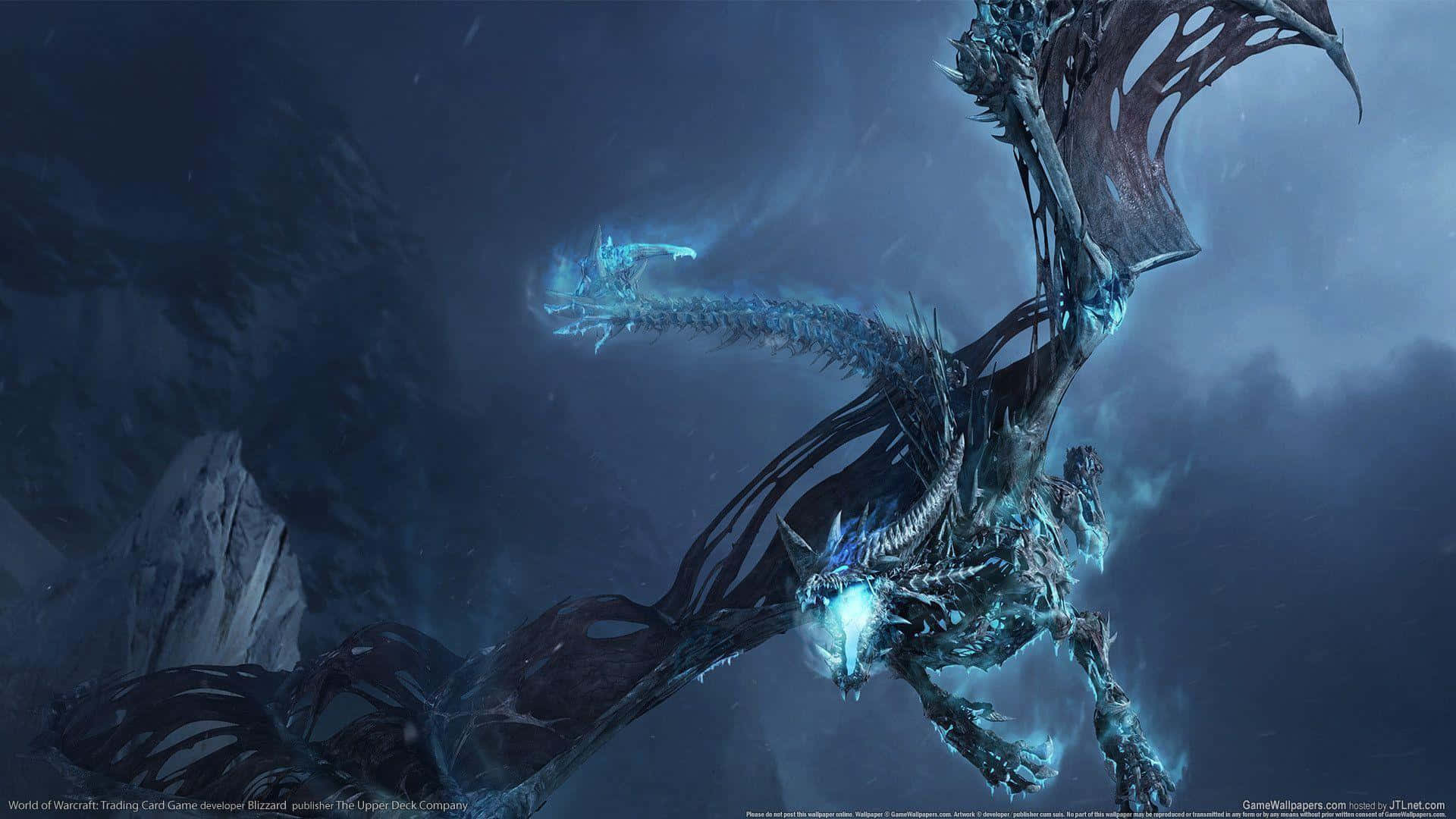 World Of Warcraft 1920x1080 桌布 壁紙 — 一隻擁有發光藍色鱗片的巨大冰龍在暴風雨的夜空中翱翔於崎嶇的山脈之上。