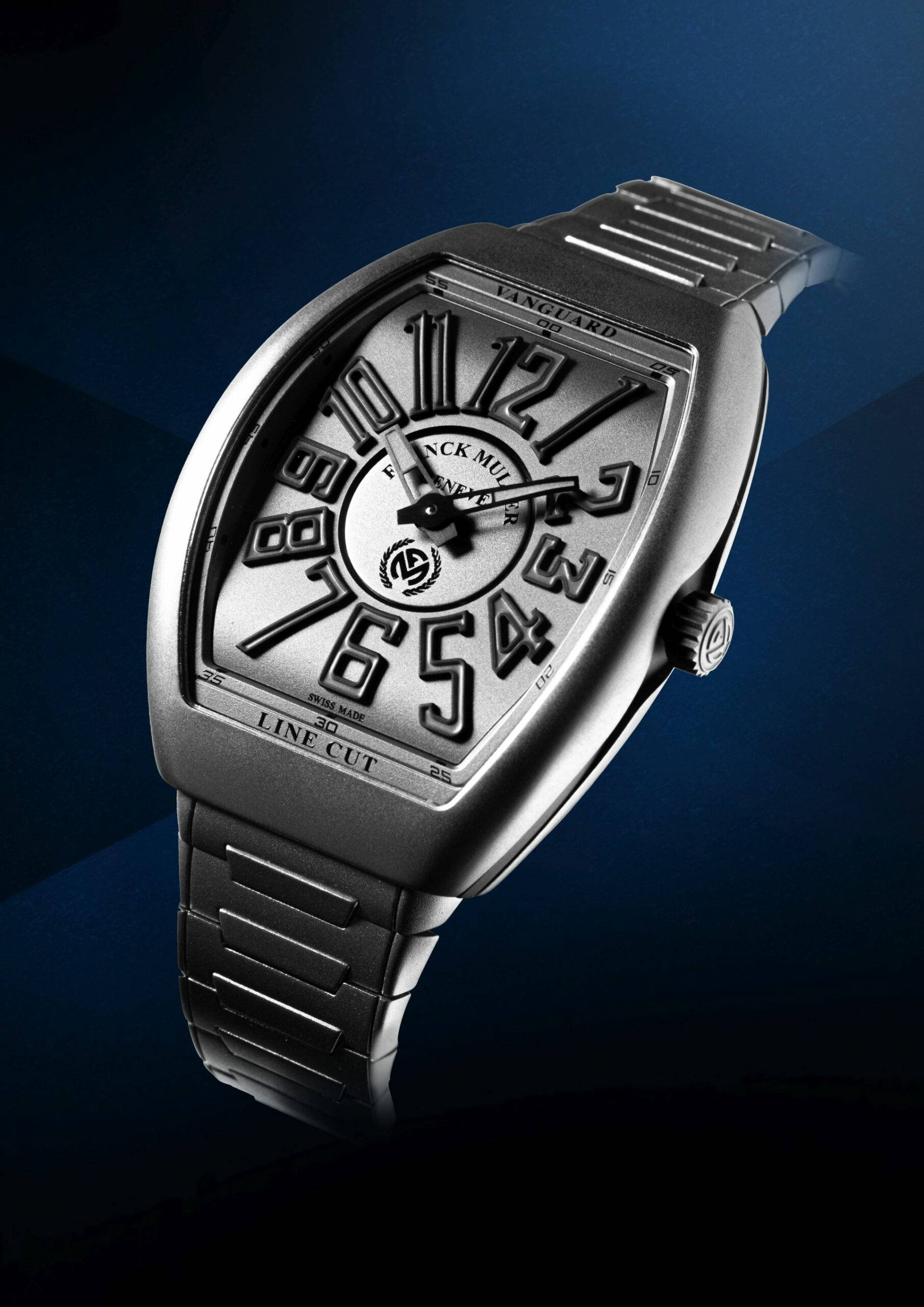 藍色 桌布 壁紙 — 一隻時尚的銀色 Franck Muller Vanguard Line Cut 手錶，帶有粗體數字，在深藍色漸變背景上閃閃發光。