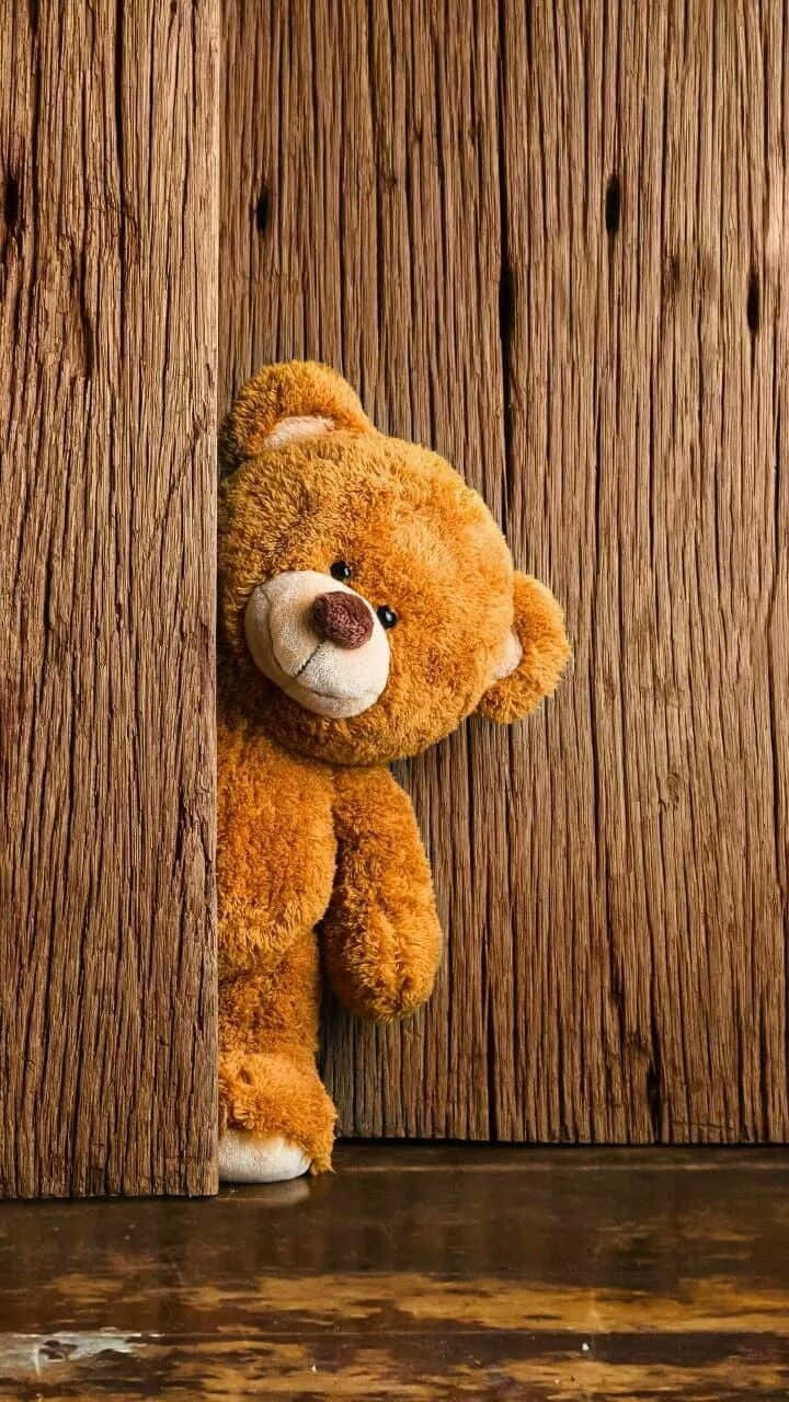Whatsapp Dp 桌布 壁紙 — 一隻柔軟的棕色泰迪熊從一扇帶有溫暖光芒的舊木門後面好奇地探出頭來。