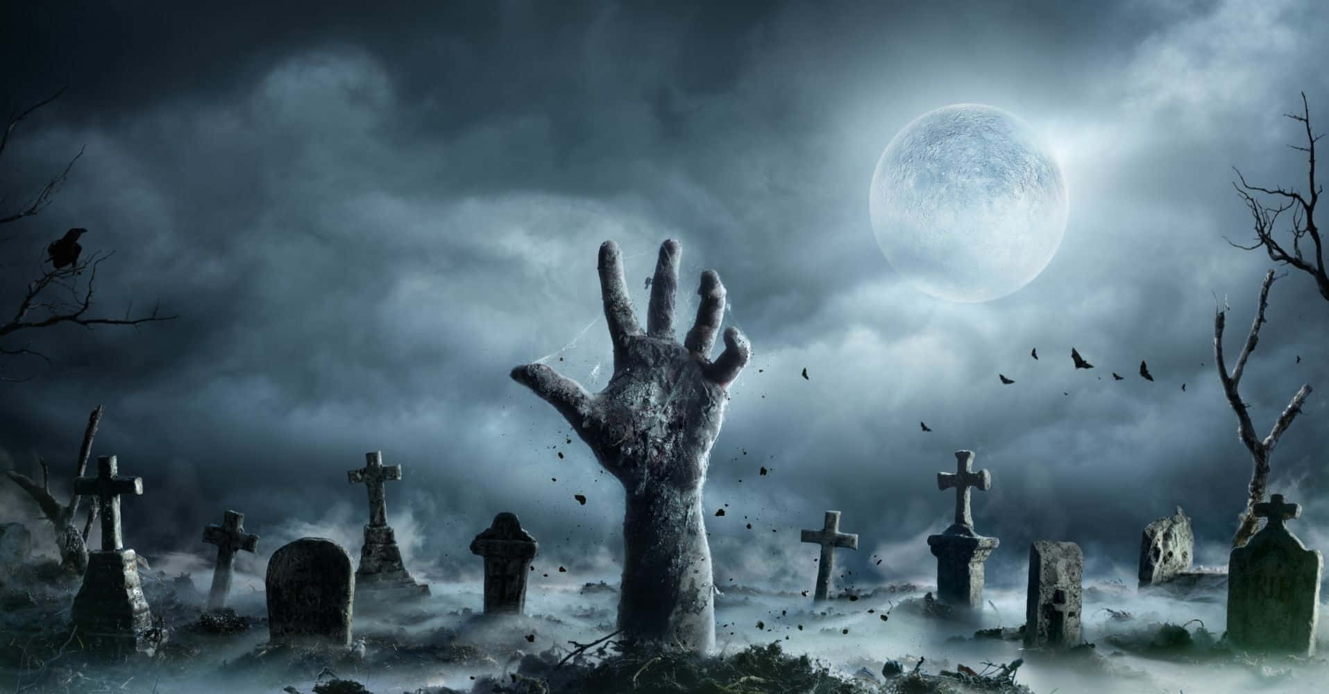 Aesthetic Creepy Halloween 桌布 壁紙 — 一隻殭屍手從霧氣瀰漫的墓地中破土而出，滿月當空，烏鴉在頭頂飛翔。