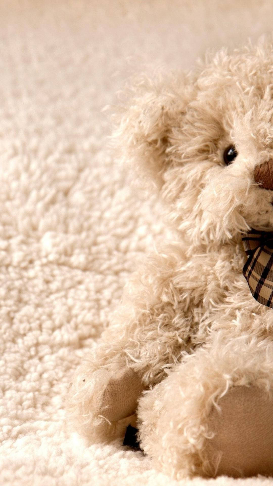 Cute Bear 桌布 壁紙 — 一隻毛絨絨的奶油色泰迪熊，戴著格子蝴蝶結，舒適地坐在柔軟有質感的毯子上。
