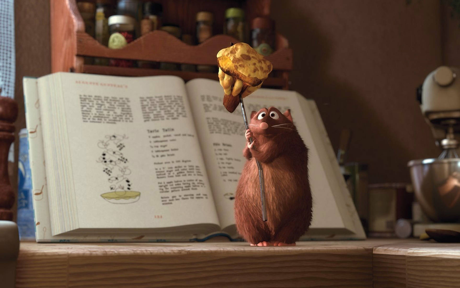 Ratatouille 桌布 壁紙 — 一隻毛茸茸的棕色動畫老鼠自豪地拿著一根棍子上的金黃色吐司，面前放著一本打開的食譜，在一個舒適的廚房裡。