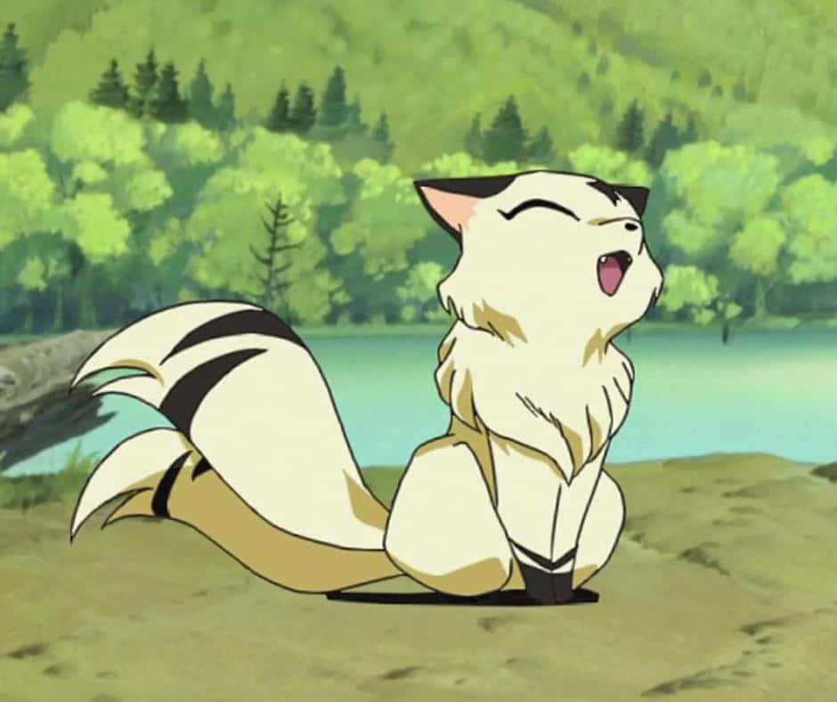 Inuyasha Nekomata 桌布 壁紙 — 一隻毛茸茸的白色狐狸帶有黑色斑紋，在寧靜的湖邊快樂地打呵欠，周圍是茂密的綠樹。