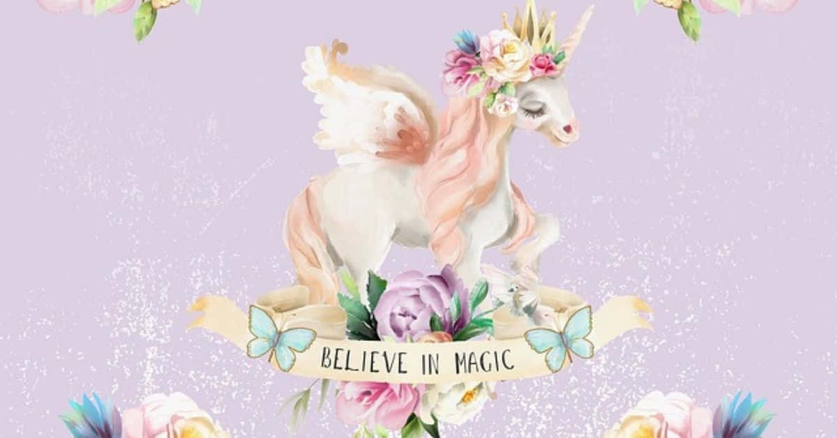  壁紙 — 一隻水彩獨角獸，頭戴花冠，背有翅膀，站在寫著believe in magic的橫幅上，周圍是粉彩花朵和蝴蝶。