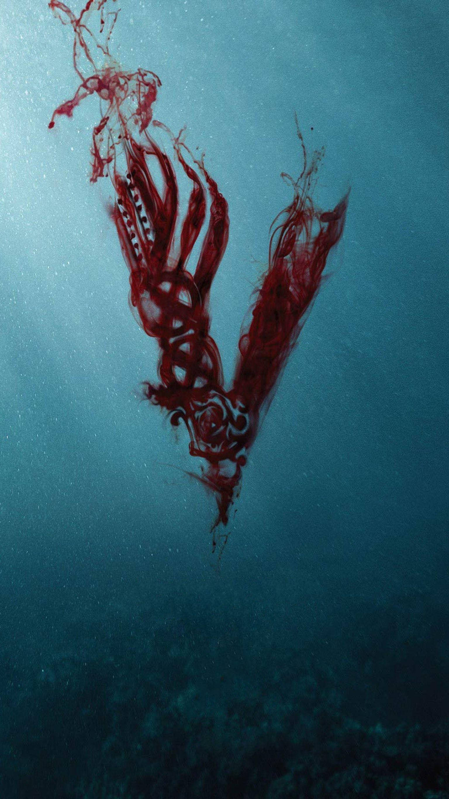 Vikings 桌布 壁紙 — 一隻深海吸血鬼魷魚在渾濁的藍色海水中滑行，帶有流動的紅色附肢和發光的白色標記。