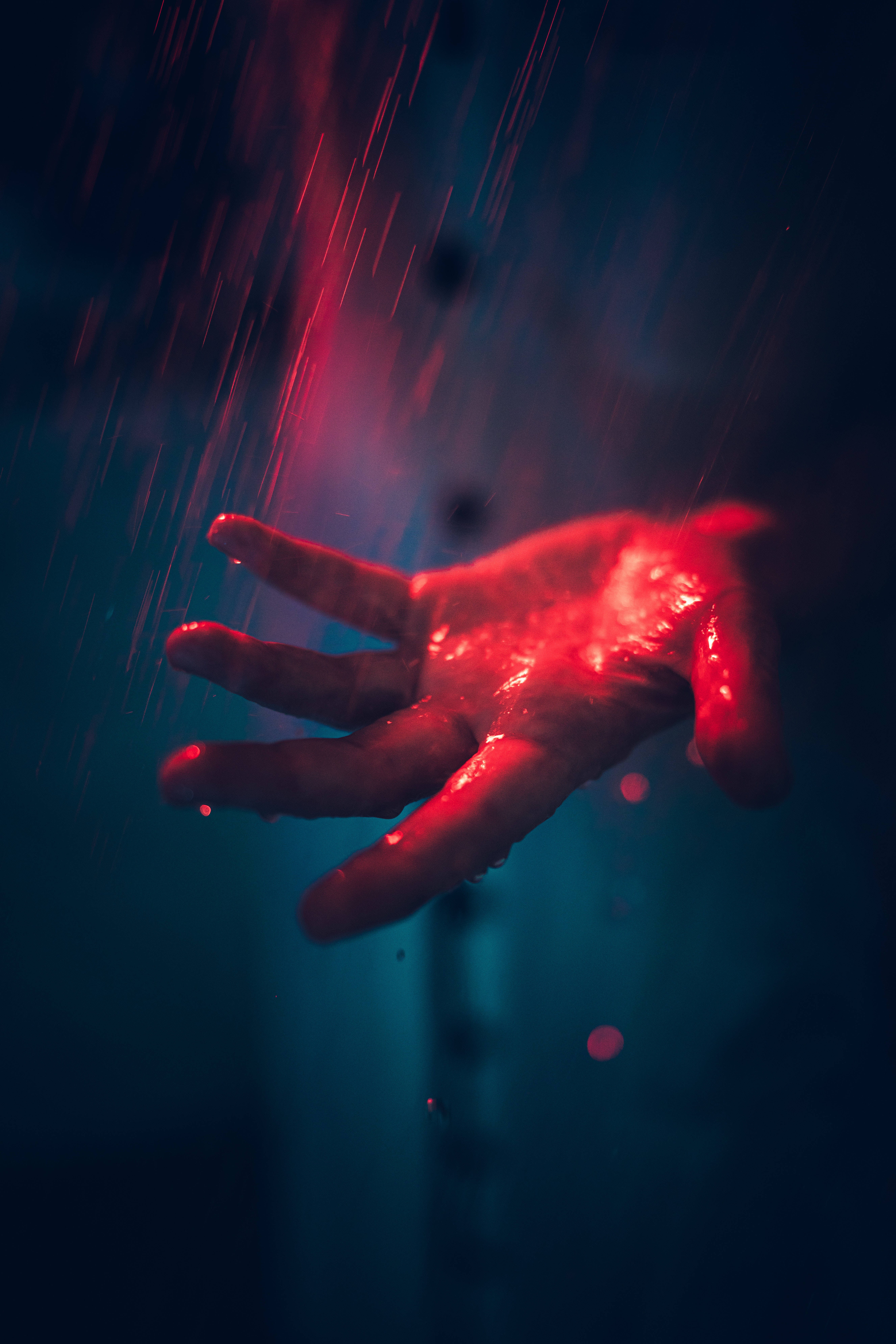 Danger 桌布 壁紙 — 一隻濕透的手在條紋光線下發出紅光，背景是深藍色並帶有雨滴。