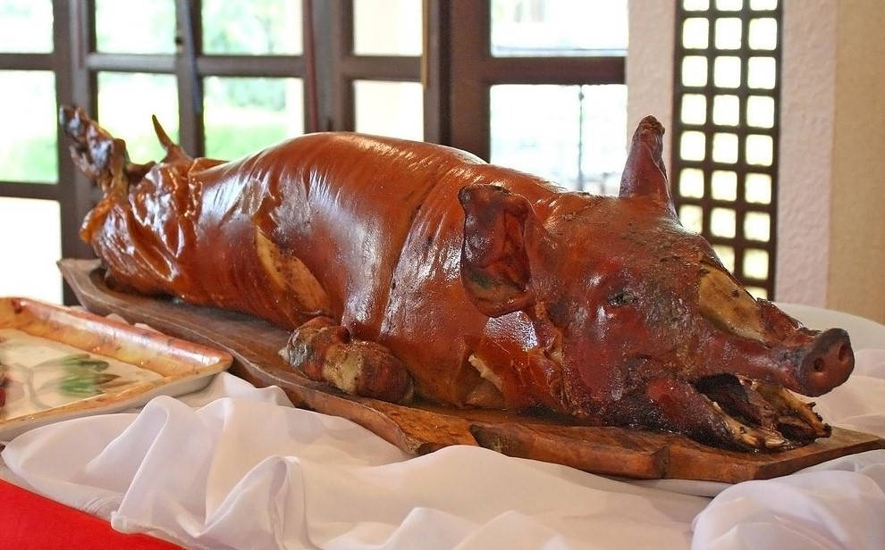 Pig 桌布 壁紙 — 一隻烤全豬，皮脆金黃，放在鋪有白布的木板托盤上。
