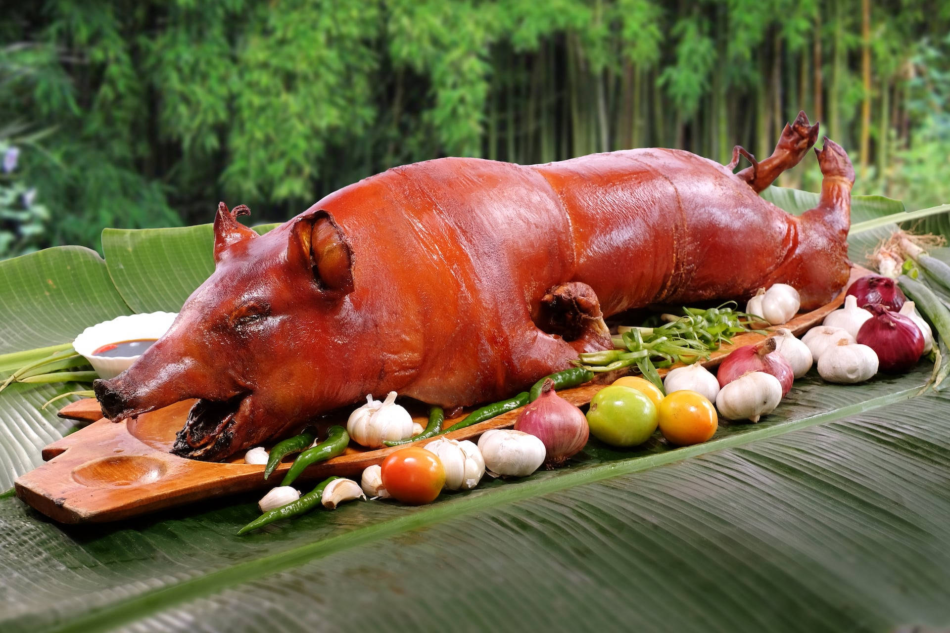香蕉葉上的烤豬，配蒜頭、辣椒和番茄 — 食物動圖 壁紙