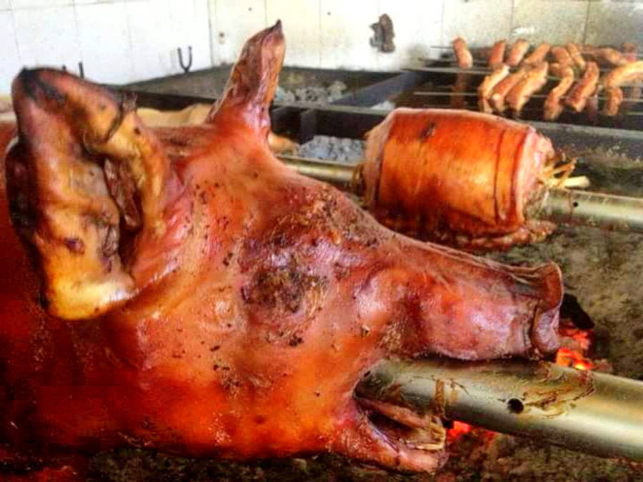 Pig 桌布 壁紙 — 一隻烤全豬在熾熱的炭火上旋轉，金黃酥脆的豬皮和附近的香腸滋滋作響。