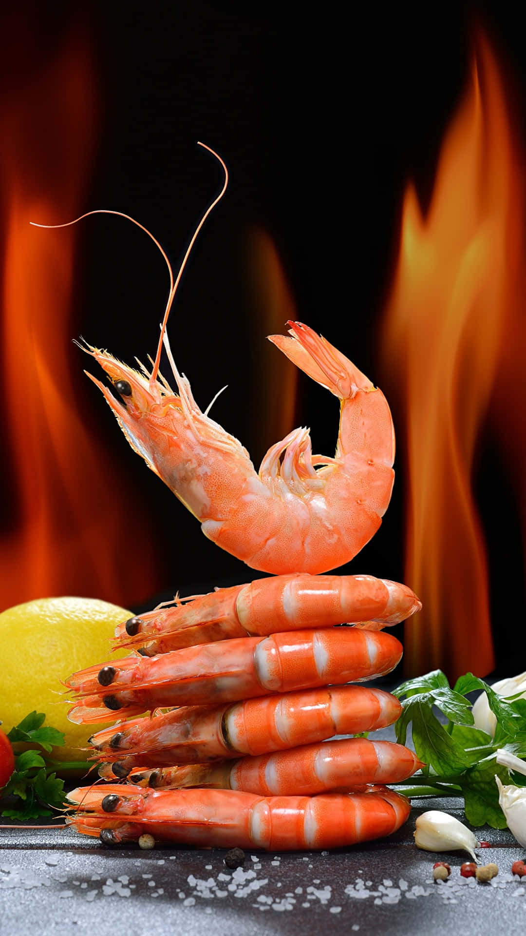 shrimp 桌布 壁紙 — 一隻熟蝦平衡在一堆生蝦之上，背景是火焰，配以檸檬香草和鹽。