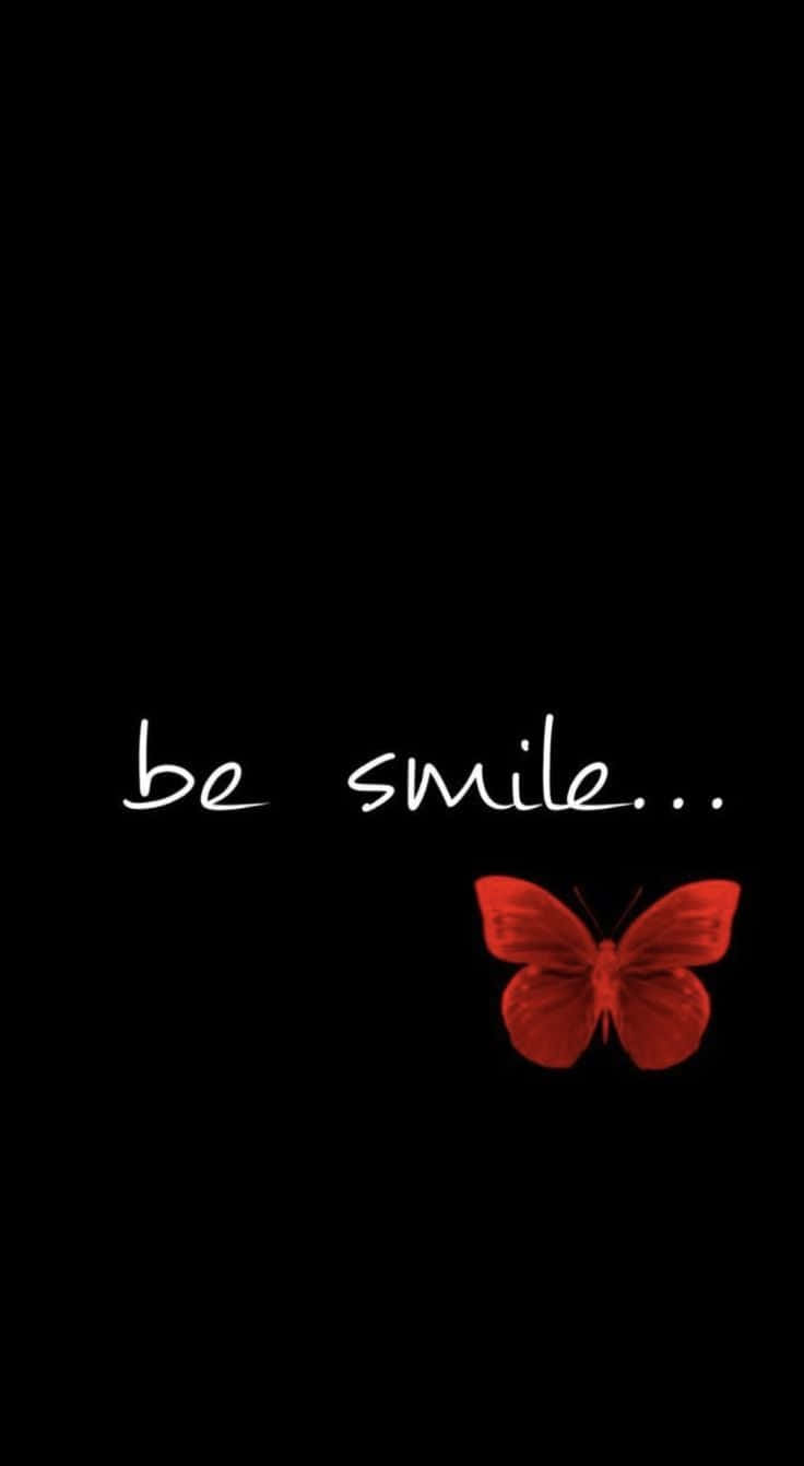 Whatsapp Dp 桌布 壁紙 — 一隻發光的紅色蝴蝶棲息在純黑背景上手寫文字「be smile」的下方。
