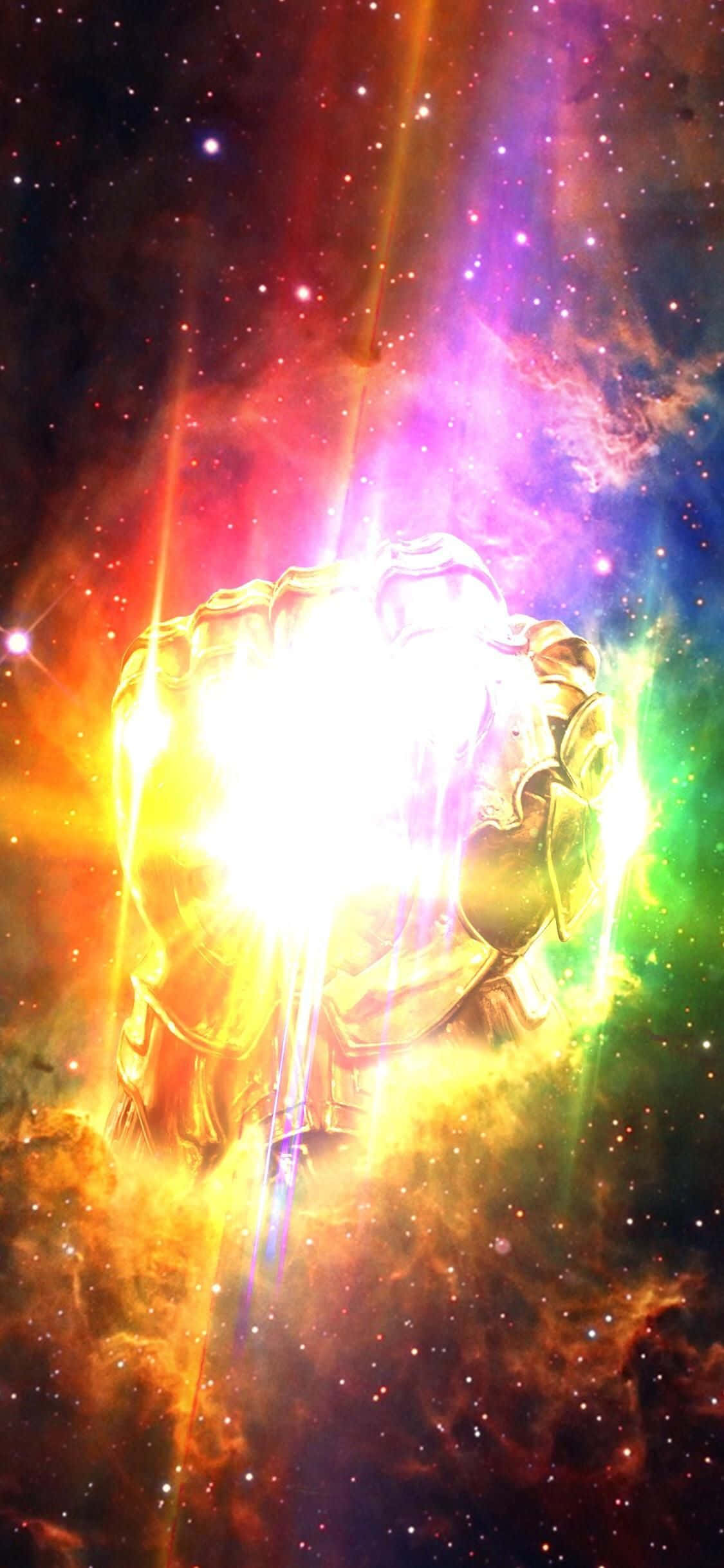 桌布 壁紙 — 一隻發光的金色手套在充滿星星和彩色氣體雲的充滿活力的宇宙星雲中散發出強烈的光芒。