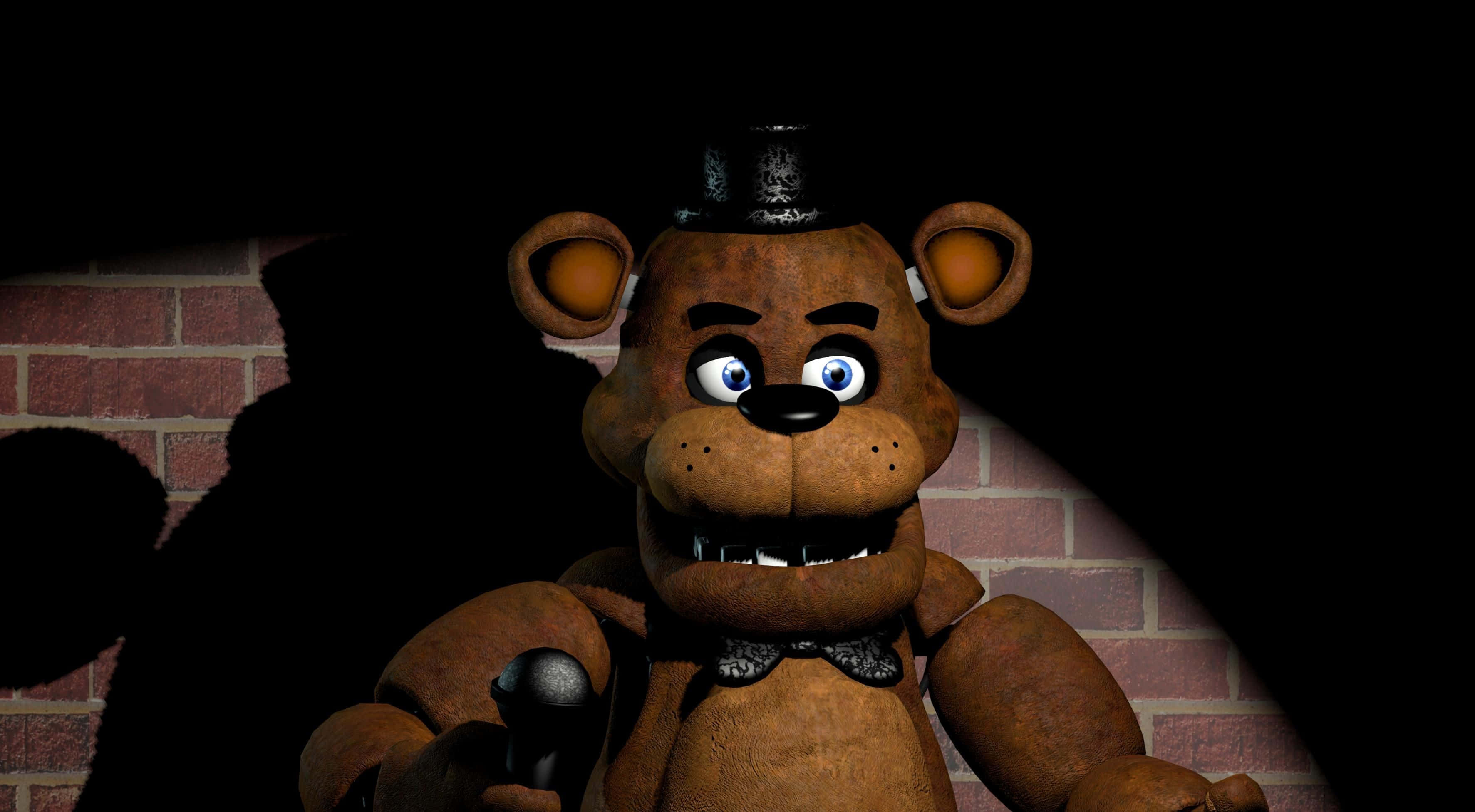 Freddy Fazbear 桌布 壁紙 — 一隻破舊的棕色機械熊，發著藍光的眼睛，戴著高帽，在聚光燈下威嚇地站在磚牆前。
