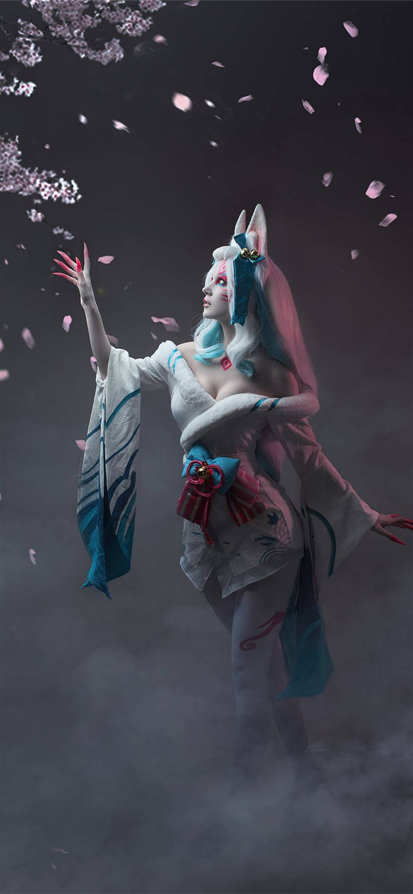 阿璃 桌布 壁紙 — 一隻神秘的狐仙穿著飄逸的白色和藍色和服，在黑暗的天空下，在飄落的櫻花中起舞。