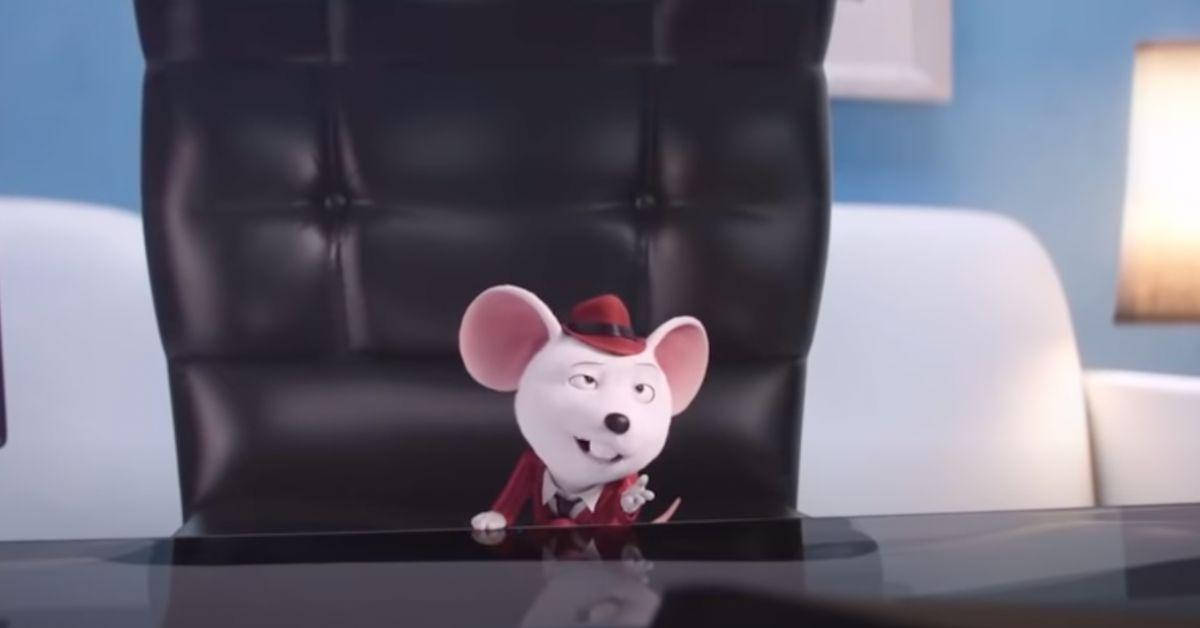 Mouse 桌布 壁紙 — 一隻穿著紅色西裝和帽子的卡通老鼠自信地坐在現代辦公室的光亮辦公桌後。