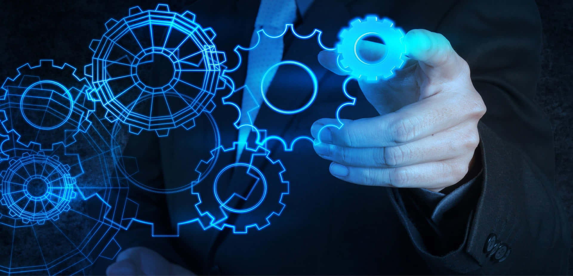Mechanical Engineering 桌布 壁紙 — 一隻穿著西裝的手與漂浮在黑暗空間中的發光藍色全息齒輪互動。