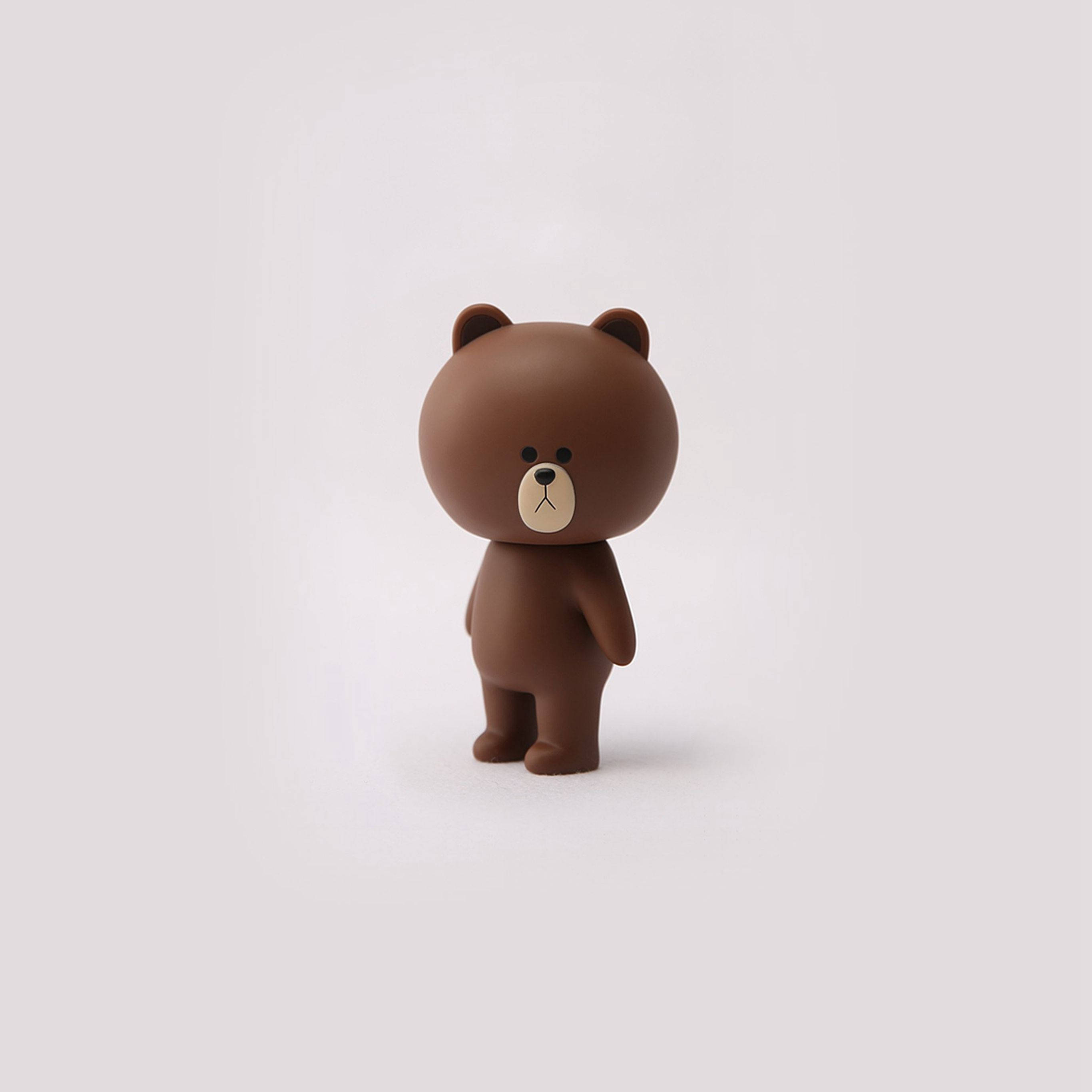 Animated 桌布 壁紙 — 一隻簡約風格的棕色小熊公仔獨自站在淺灰色背景上，帶有柔和陰影。