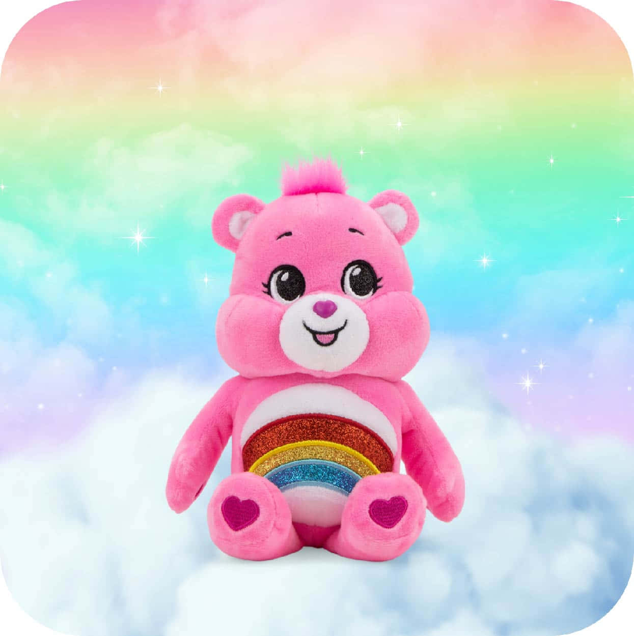 彩虹熊 桌布 壁紙 — 一隻粉紅色毛絨 Care Bear，腹部有閃閃發光的彩虹，坐在蓬鬆的雲朵上，背景是粉彩彩虹天空，有閃爍的星星。