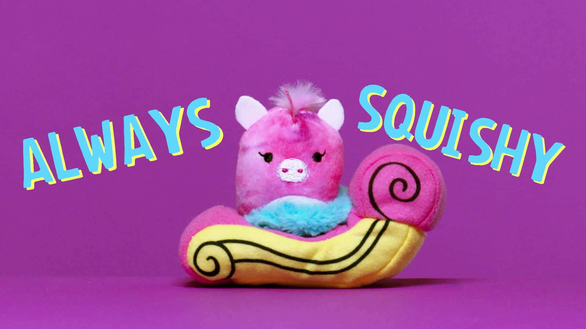 粉紅色毛絨豬玩具在黃色蝸牛殼中，帶有「Always Squishy」文字。 — Squishmallows 壁紙