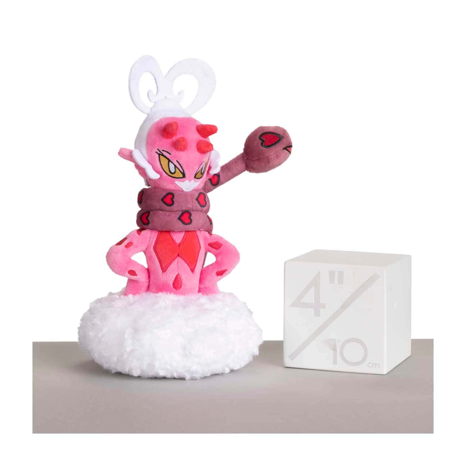 寶可夢 桌布 壁紙 — 一隻粉紅色的 Pokémon Clefable 毛絨玩具在白色絨毛底座上自信地擺姿勢，旁邊有一個白色比例立方體。