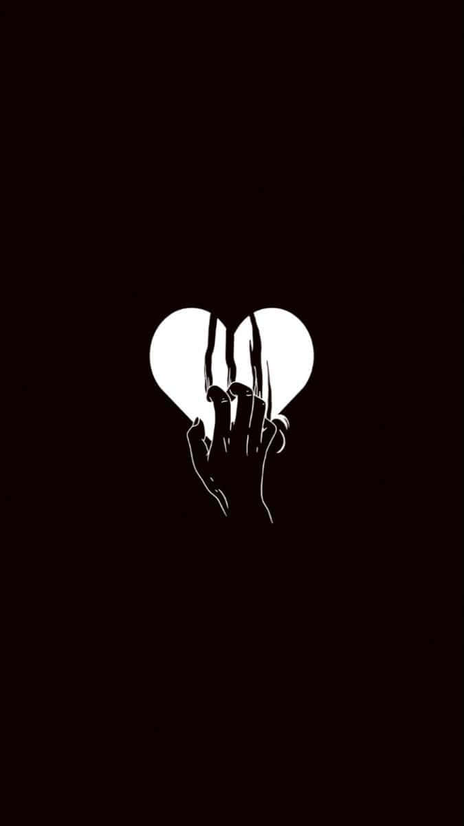 Aesthetic Black Heart 桌布 壁紙 — 一隻純白的手在深黑色背景上將心臟撕成兩半。