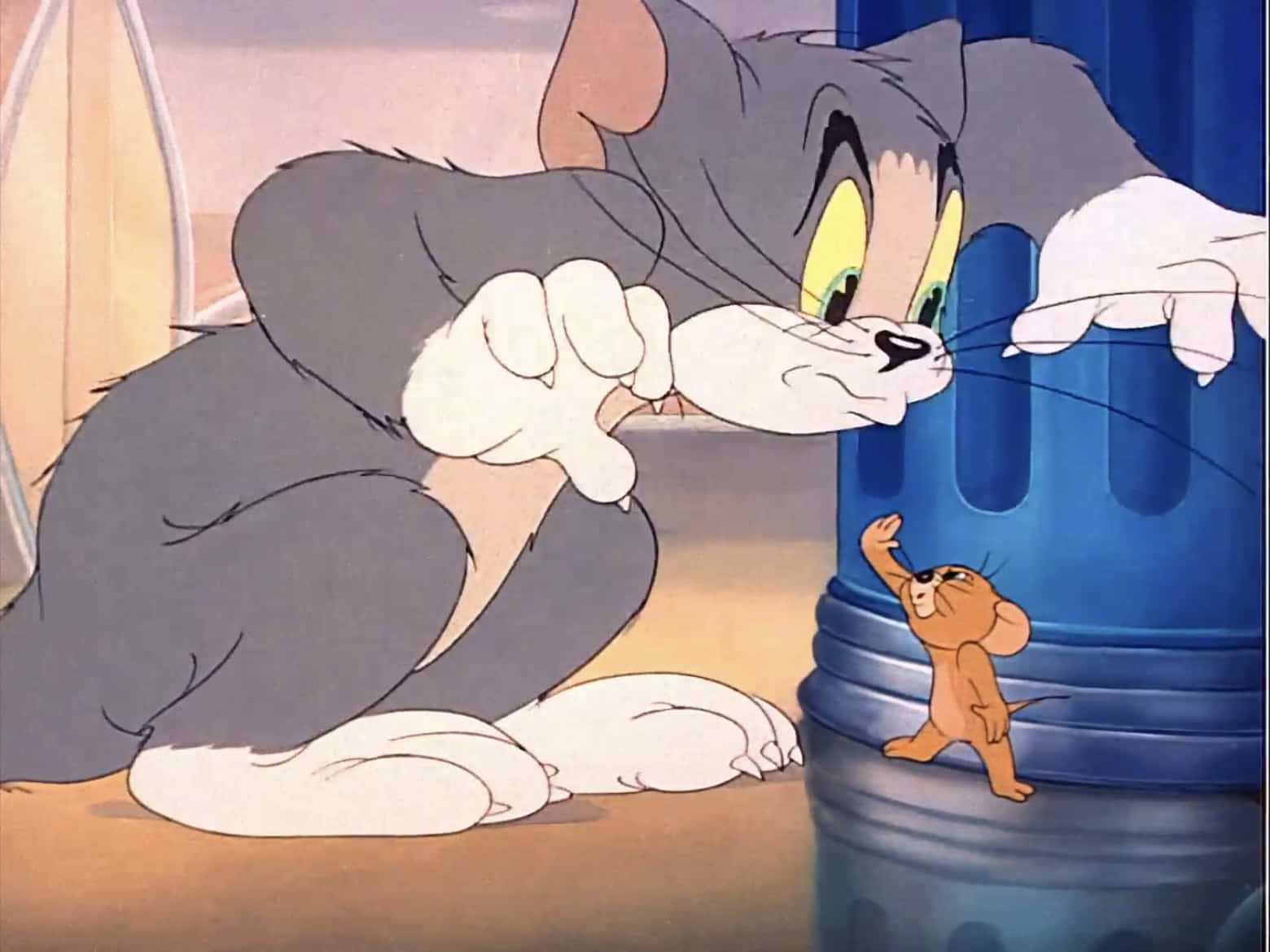 Tom And Jerry Funny 桌布 壁紙 — 一隻經典卡通貓威嚇性地俯身在一個藍色垃圾桶上，面向一隻細小的老鼠挑釁地站在桶邊。