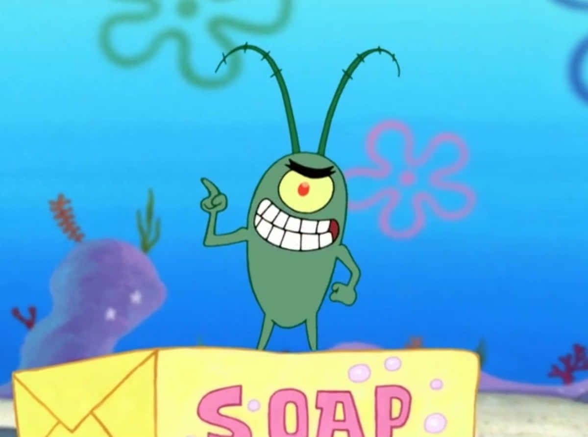 plankton 桌布 壁紙 — 一隻綠色單眼卡通昆蟲，長有觸角，站在藍色水下場景中的黃色肥皂盒上。