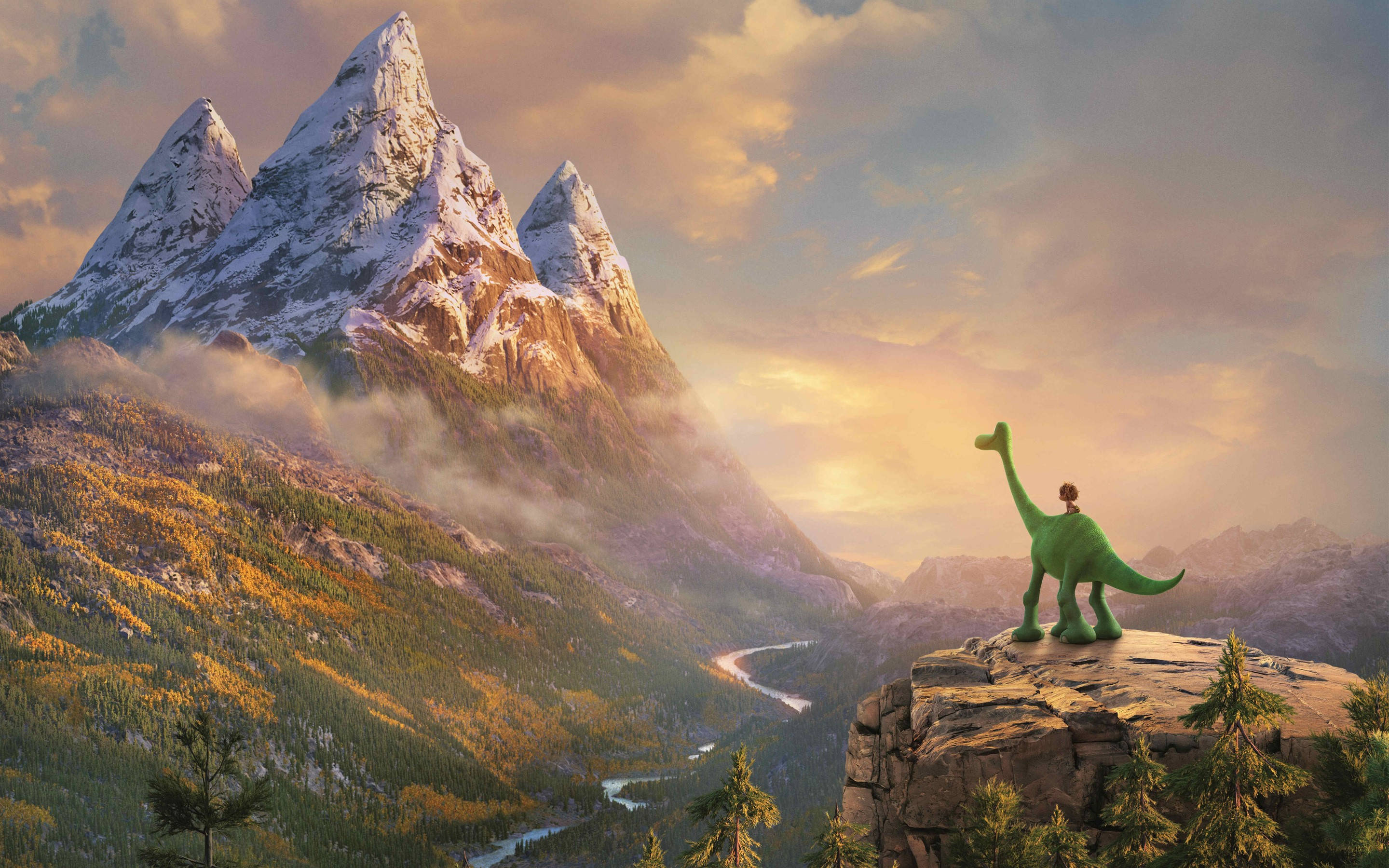 The Good Dinosaur 桌布 壁紙 — 一隻綠色恐龍站在岩石懸崖上，俯瞰著日落時分有雪山和蜿蜒河流的山谷。