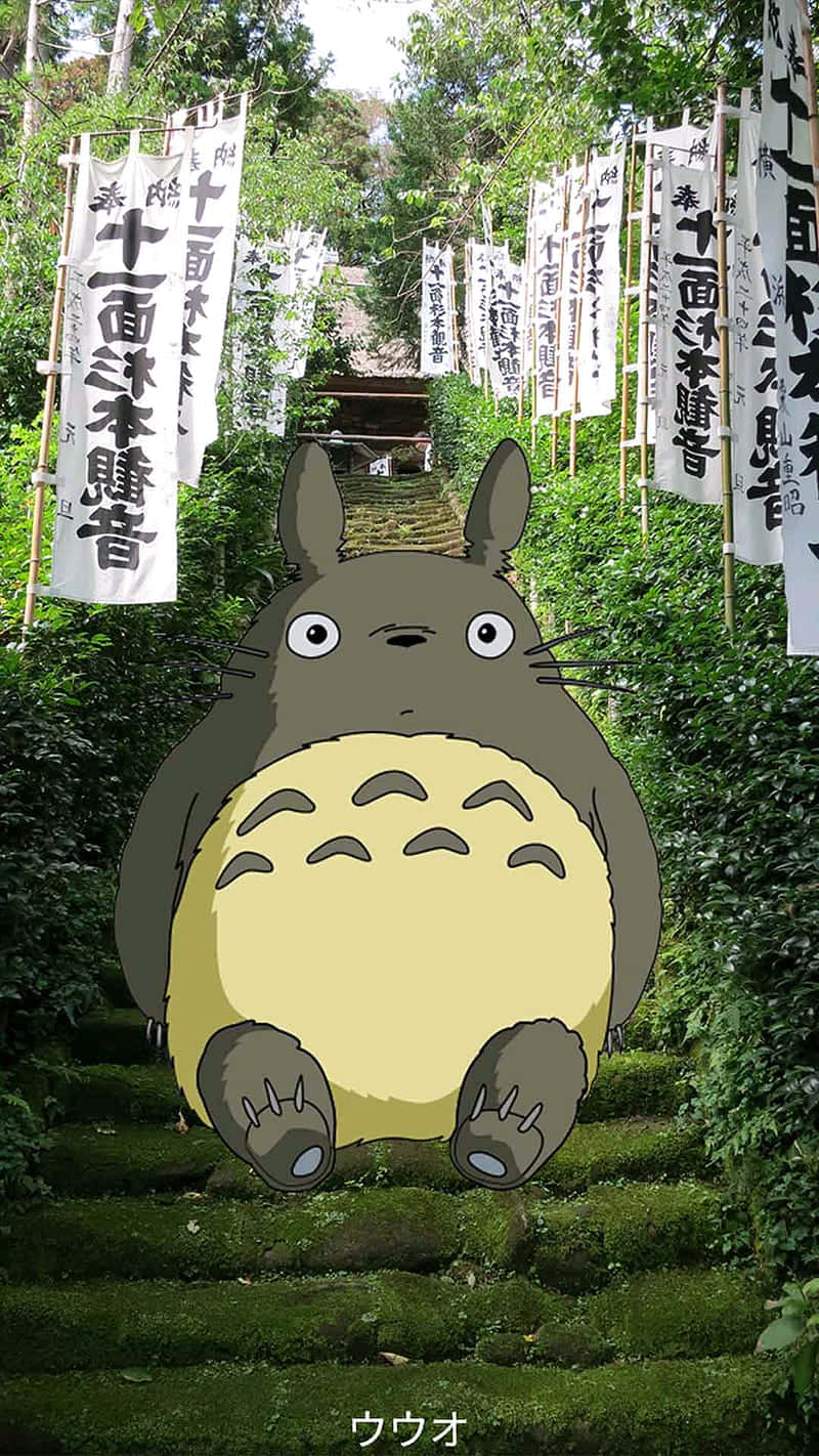 edit 桌布 壁紙 — 一隻綠色的大龍貓坐在長滿青苔的石階上，兩旁有白色旗幟，身處茂密的森林中。