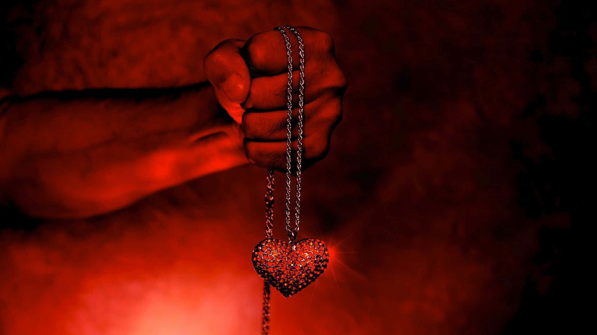 Dark Love 桌布 壁紙 — 一隻緊握的拳頭拿著一條鏈上的閃爍心形吊墜，背景是煙霧彌漫的紅色。