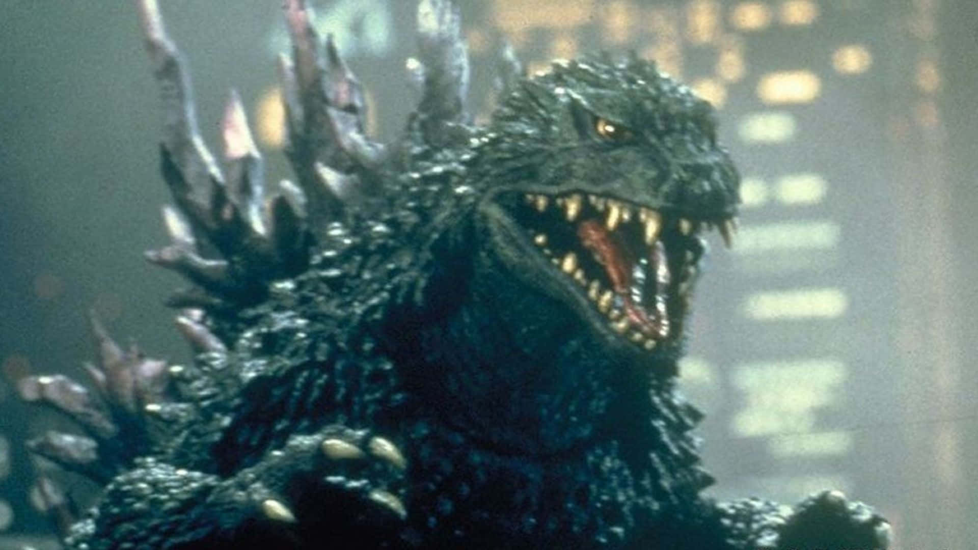 Godzilla 2000 桌布 壁紙 — 一隻背上有刺、眼睛發光的怪獸哥吉拉在夜晚煙霧瀰漫的城市景觀中咆哮。