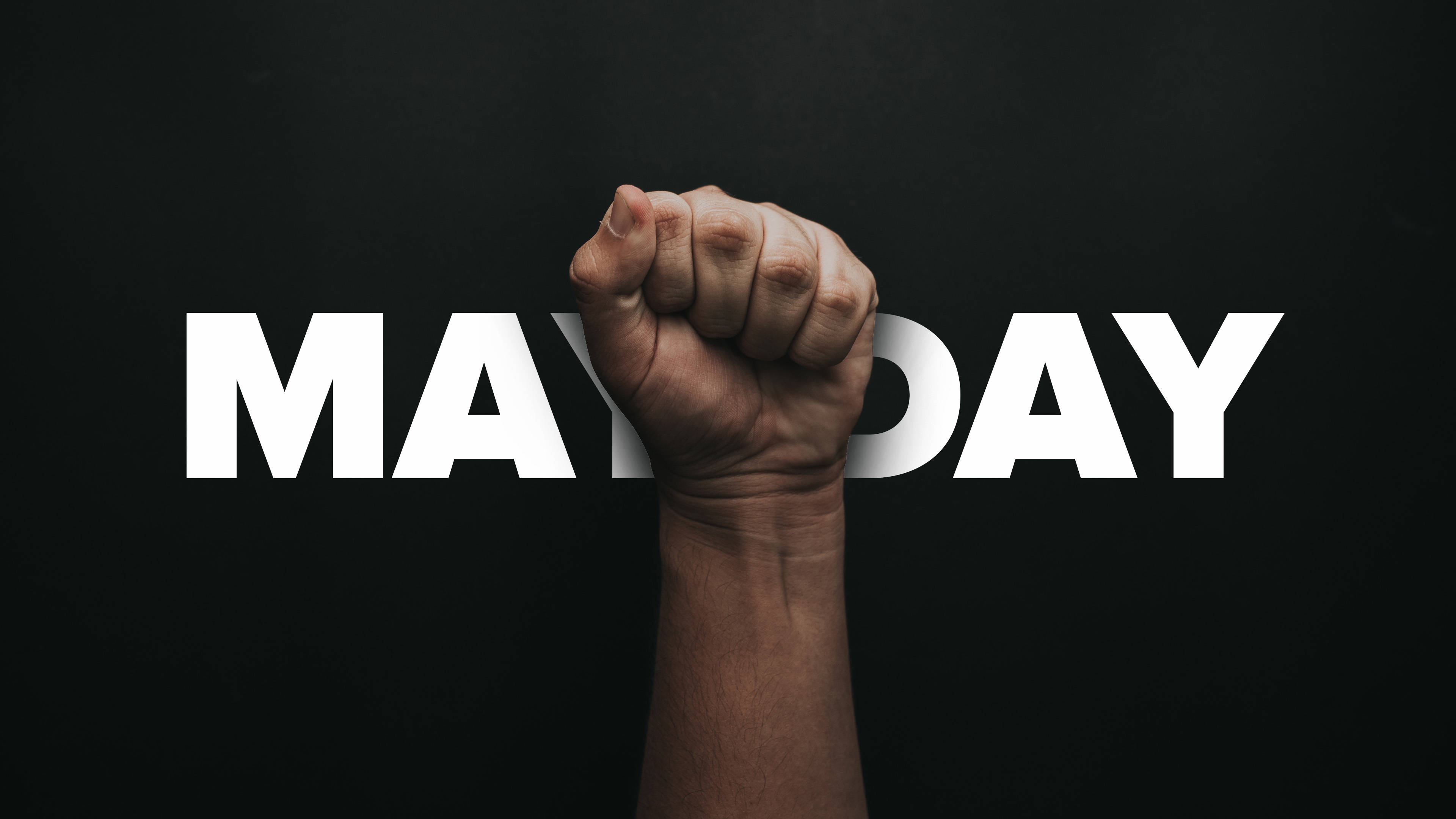 五月天 桌布 壁紙 — 一隻舉起的拳頭穿過粗體白色文字，拼寫出 MAYDAY，背景為黑色。