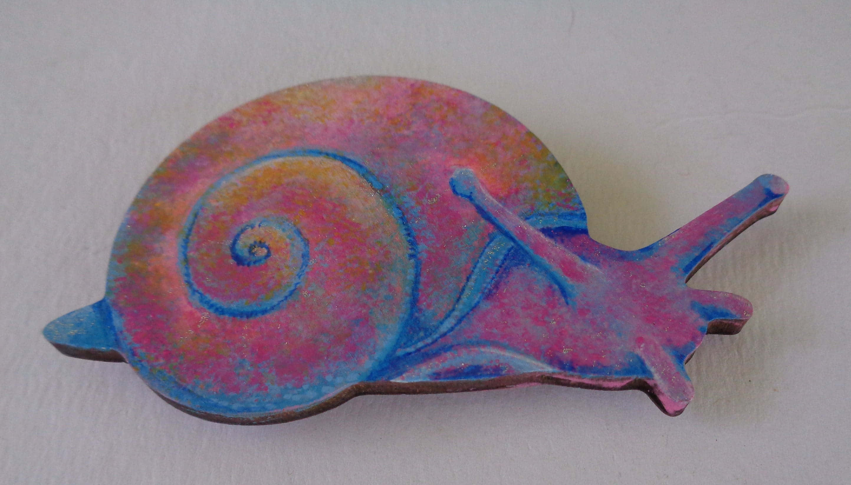 Pink Snail 桌布 壁紙 — 一隻色彩鮮豔的陶瓷蝸牛，帶有旋轉的粉紅色、藍色和橙色色調，放置在純白色的表面上。