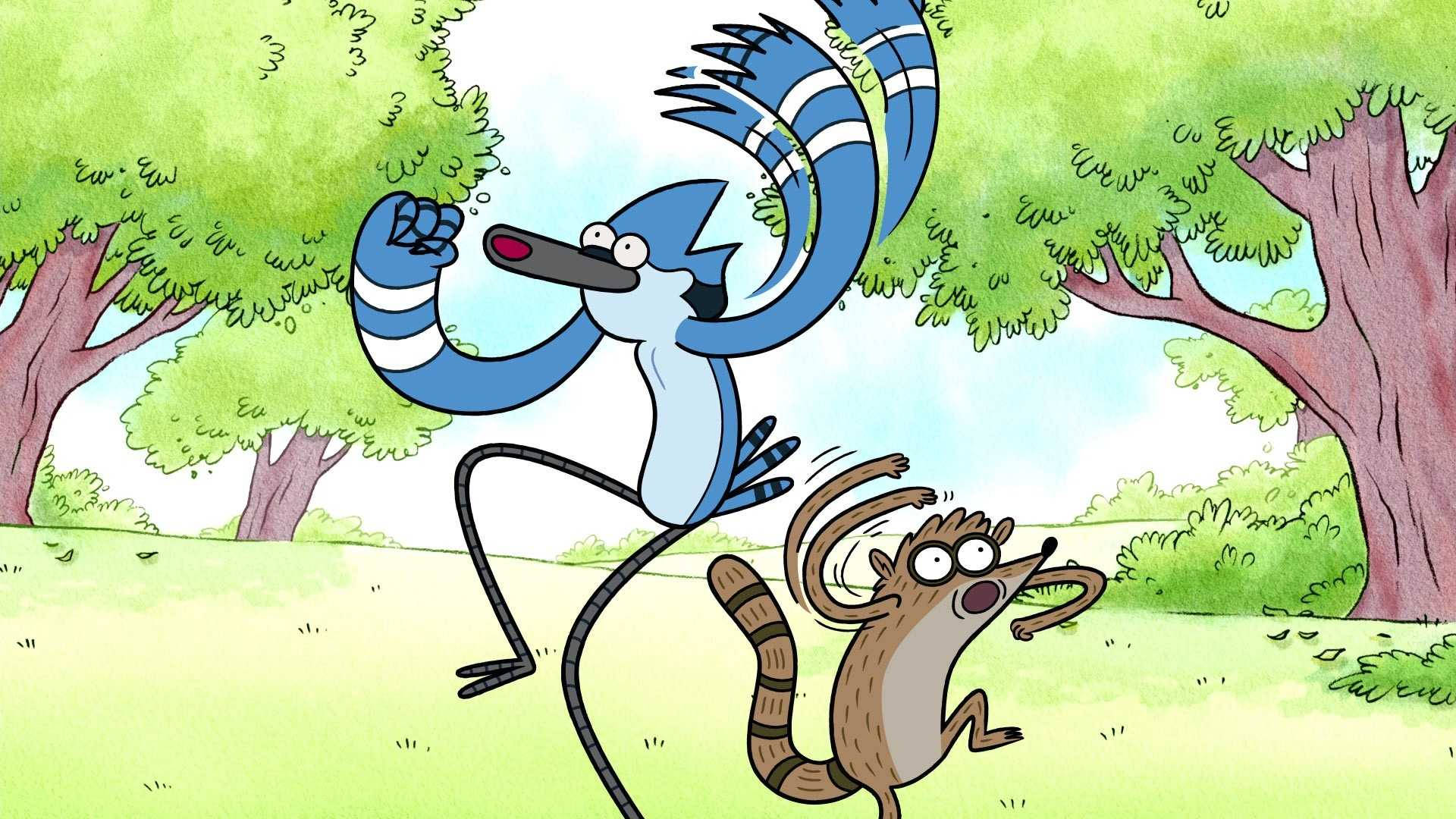 mordecai and rigby 桌布 壁紙 — 一隻藍松鴉和一隻浣熊在陽光明媚的森林空地中充滿活力地跳躍，帶有誇張的卡通動作。