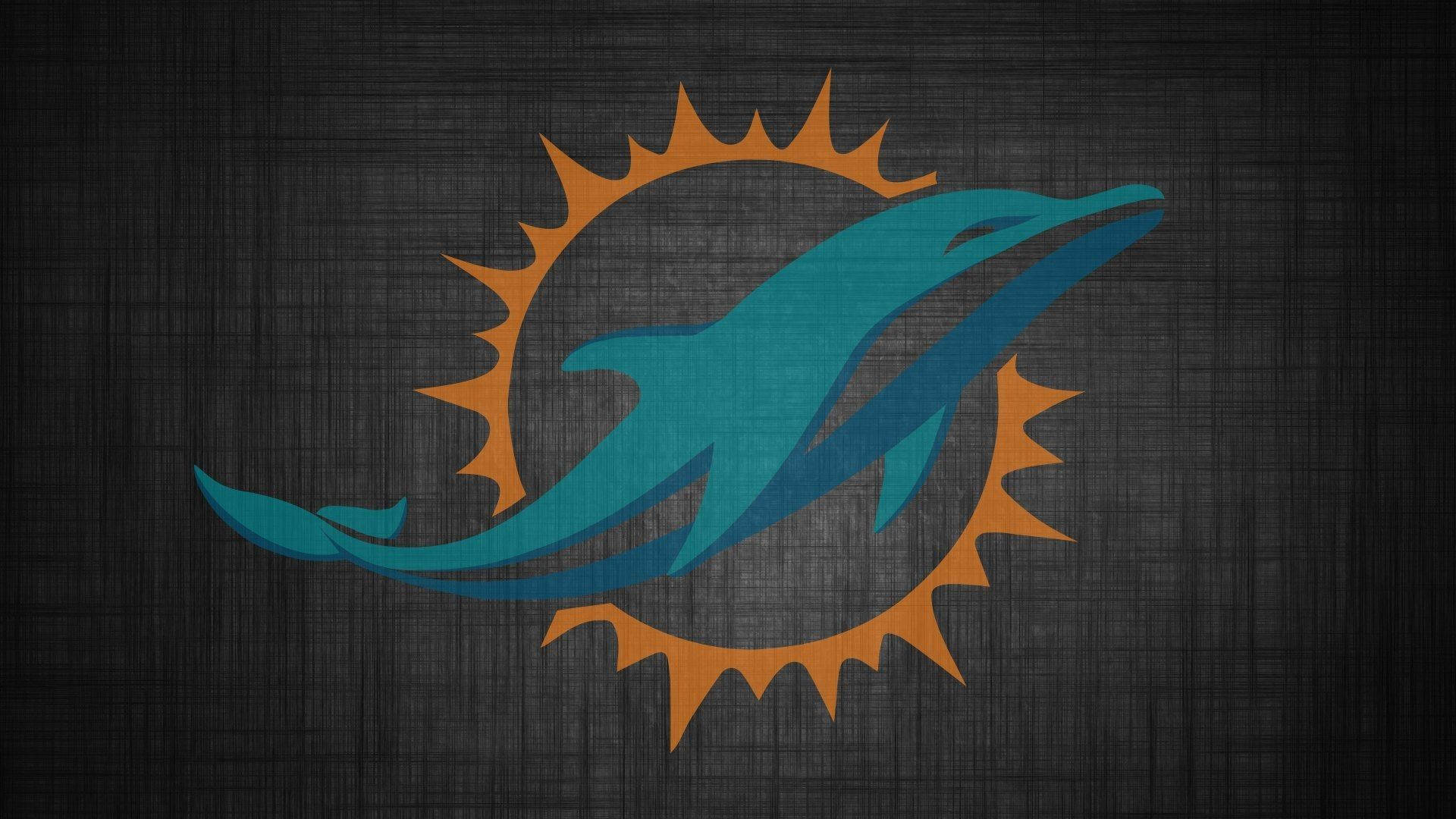 dolphins 桌布 壁紙 — 一隻藍綠色海豚跳過橙色太陽爆發標誌，背景為深色紋理。