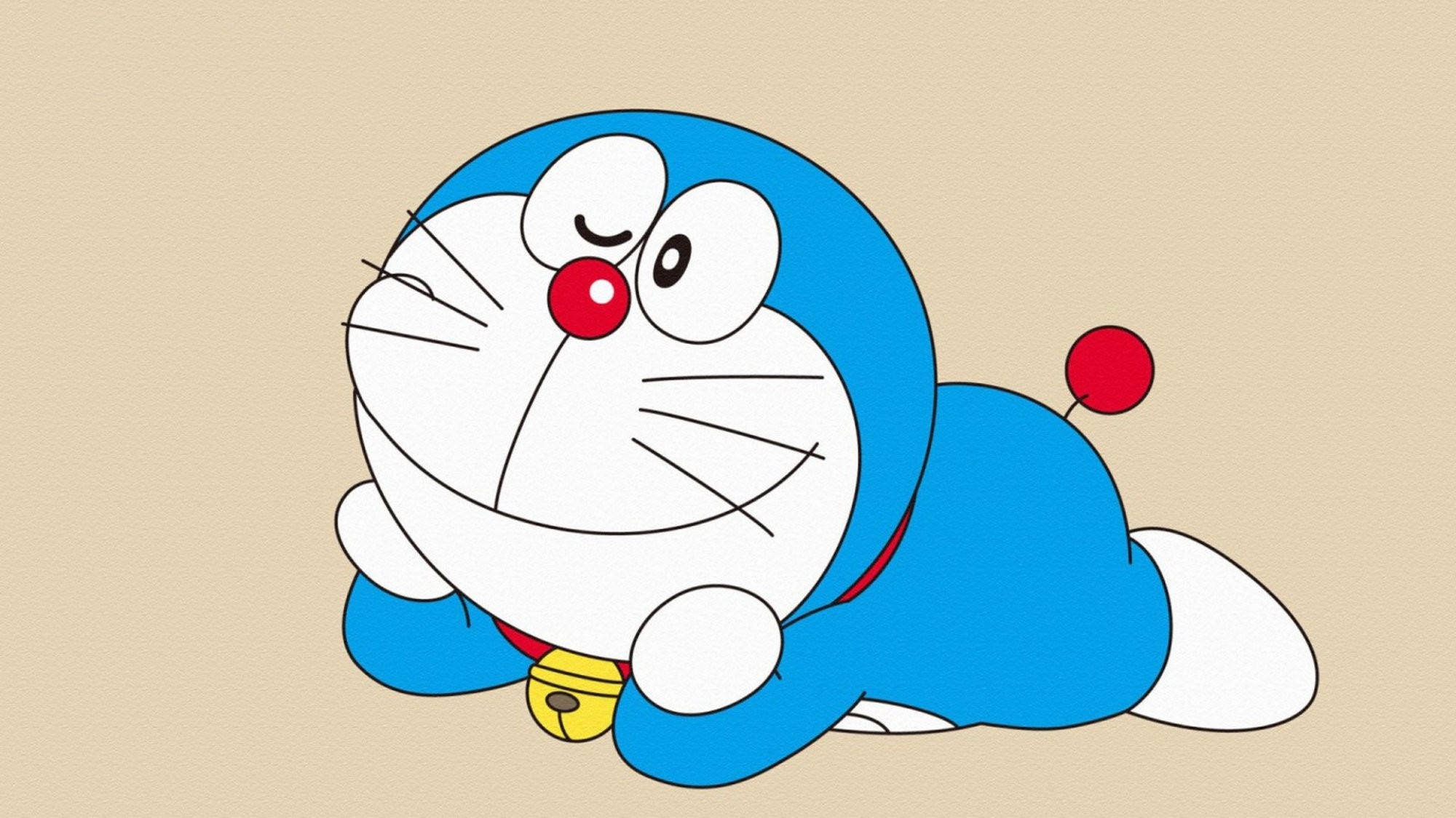 Doraemon 桌布 壁紙 — 一隻藍色機器貓，紅鼻子，掛著鈴鐺，蜷縮在米色背景上，表情愉快。