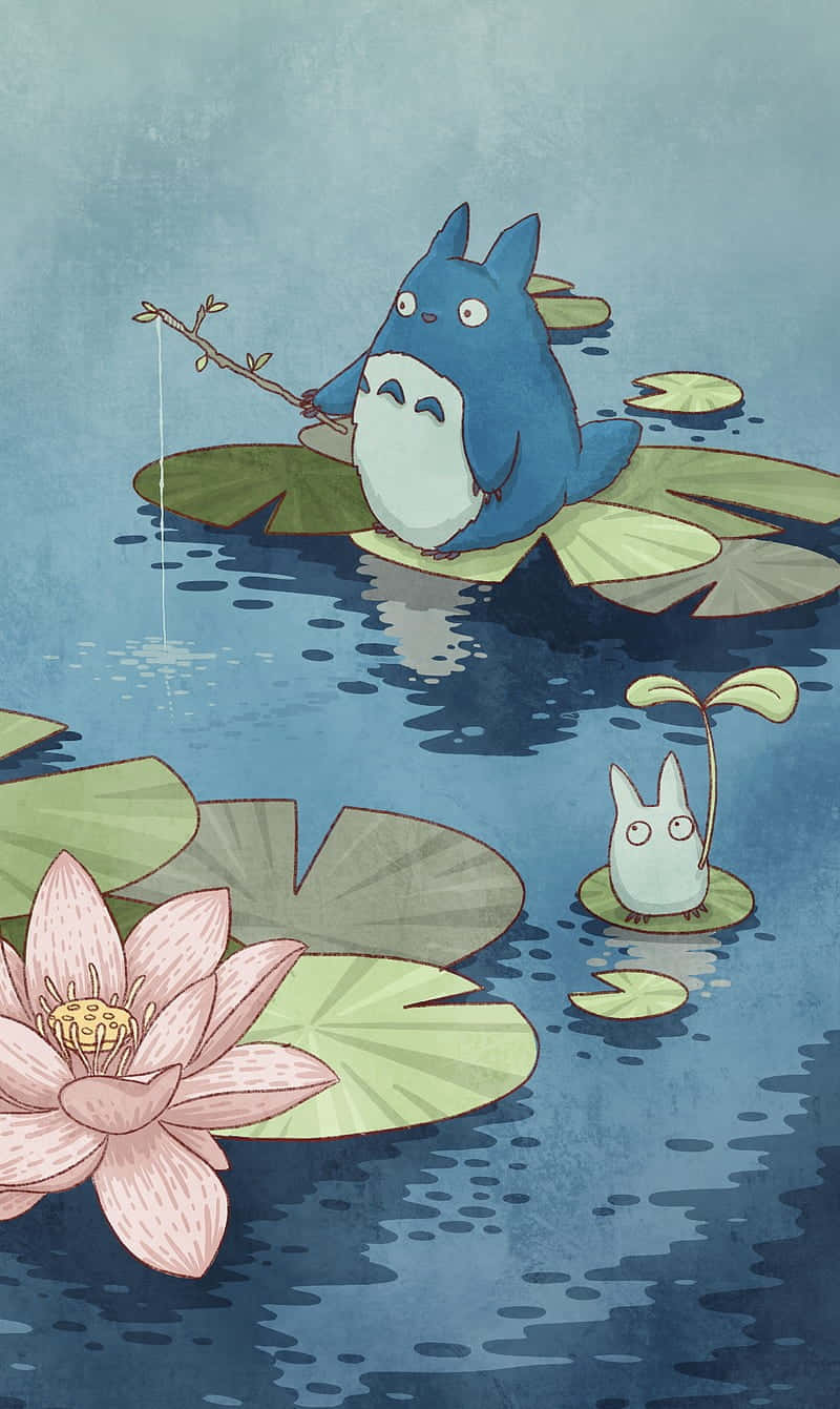 藍色龍貓在荷葉上釣魚，附近有小白龍貓和粉紅蓮花。 — 龍貓 GIF 壁紙
