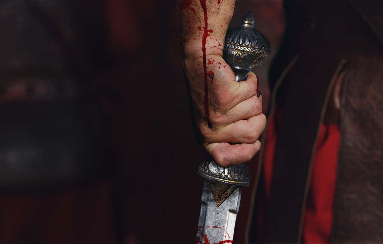 Blood Dripping 桌布 壁紙 — 一隻血淋淋的手緊握著一把華麗的匕首，深紅色的污漬沿著刀刃和手臂滴落。