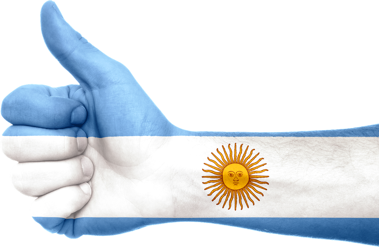 Argentina 桌布 壁紙 — 一隻豎起大拇指的手，塗有阿根廷國旗的藍、白、金色太陽圖案。