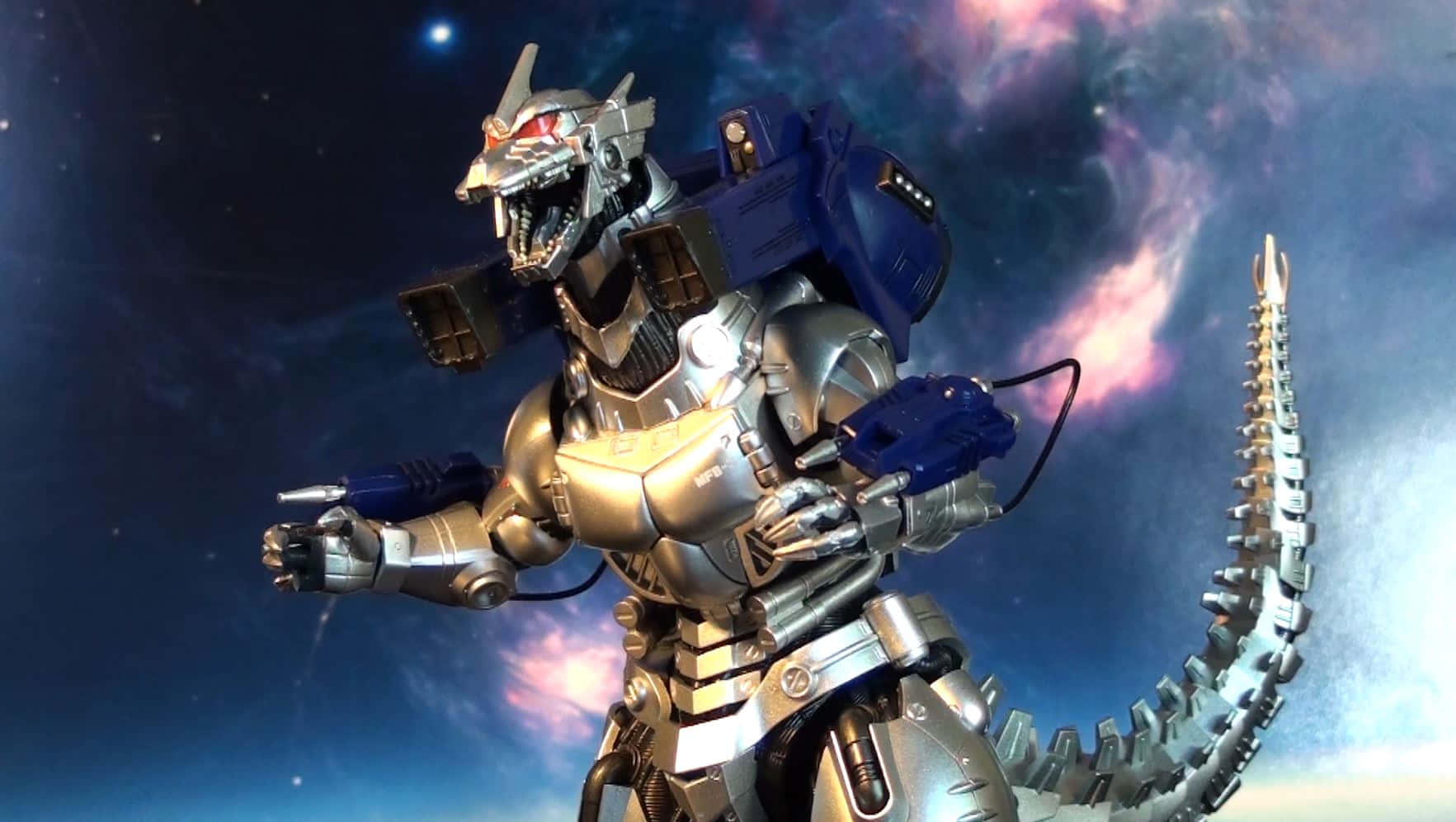 mechagodzilla 桌布 壁紙 — 一隻金屬機械哥斯拉在充滿發光星星的鮮豔宇宙星雲背景下擺好姿勢。