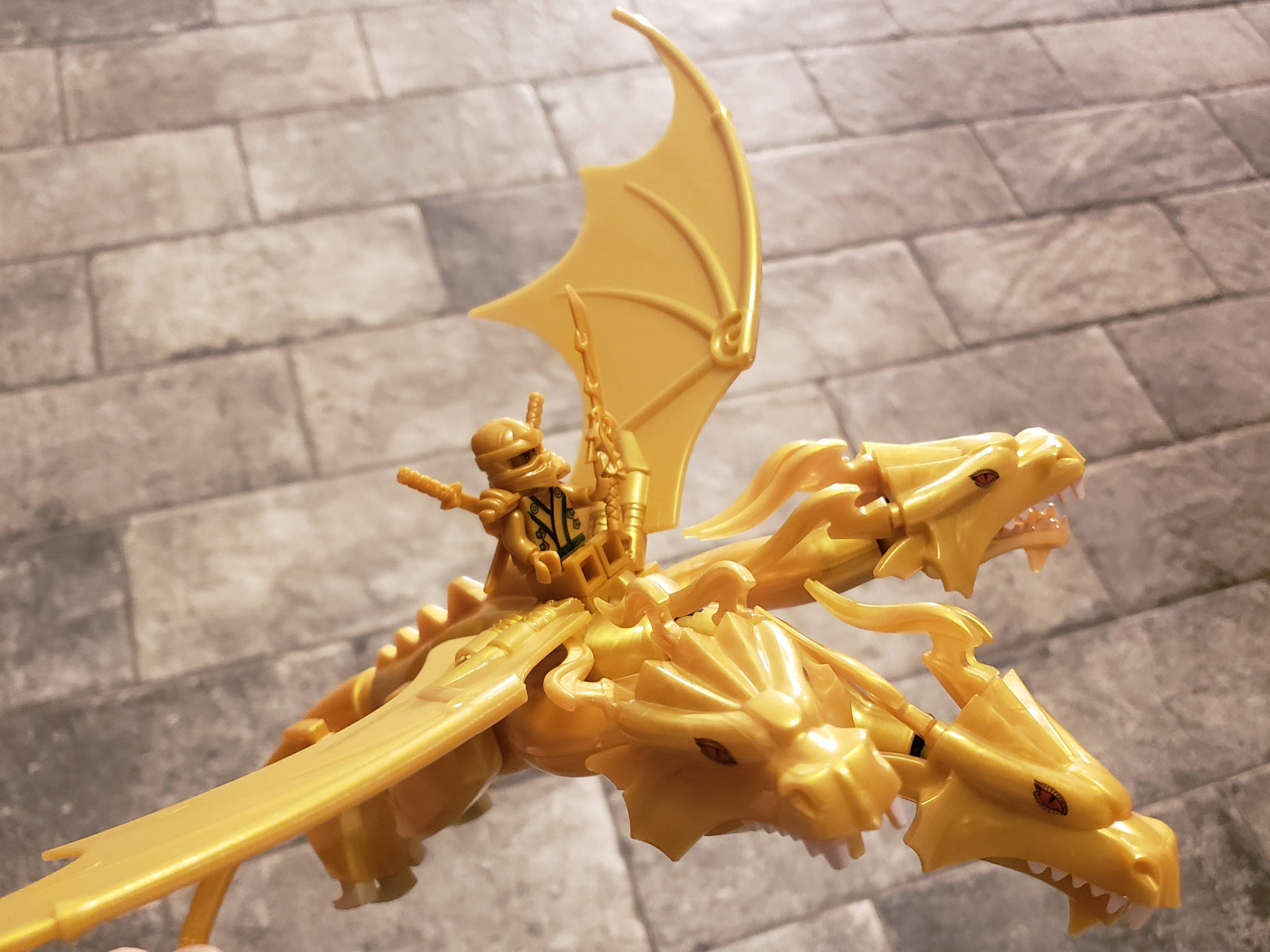 Gold Dragon 桌布 壁紙 — 一隻金色LEGO龍，有三個頭和一個騎手，立於石磚地上。