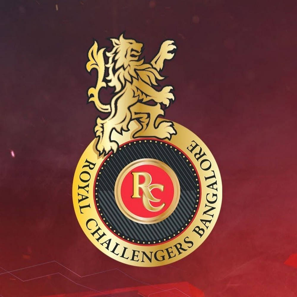 royal challengers bangalore 桌布 壁紙 — 一隻金色獅子矗立在 Royal Challengers Bangalore 標誌之上，背景為豐富的酒紅色紋理背景。
