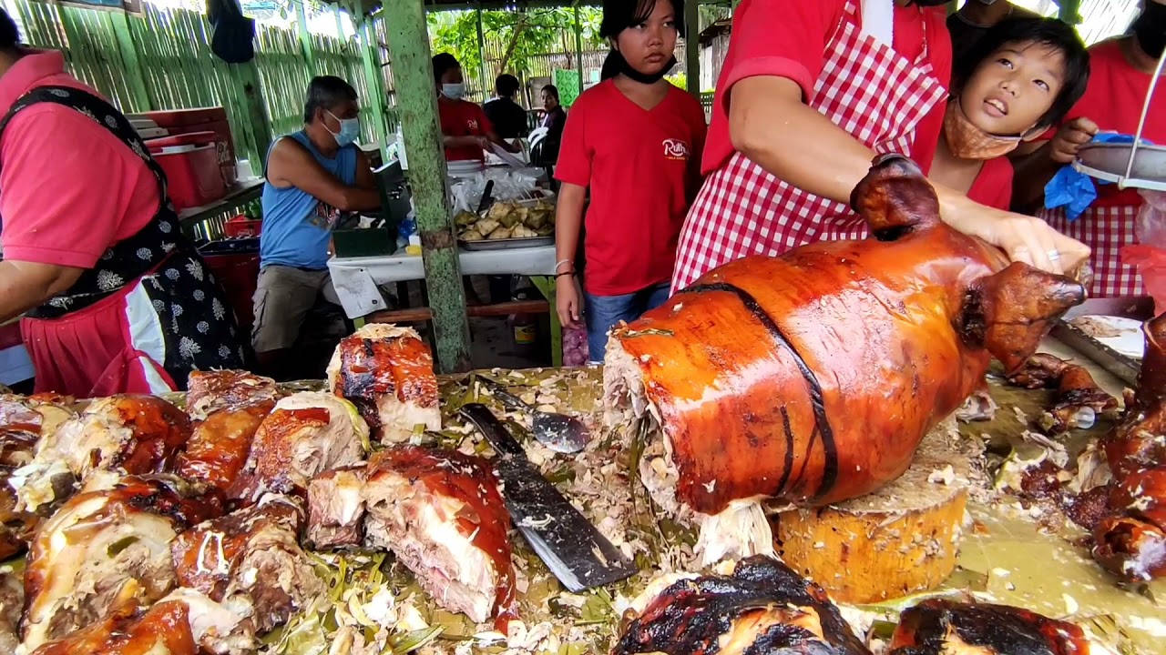 Pig 桌布 壁紙 — 一隻金黃酥脆的烤全豬正在一個熙來攘往的戶外美食攤位被切開，周圍擠滿了人。