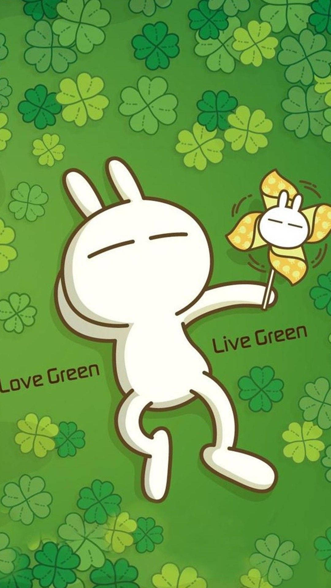 可愛的機器人 桌布 壁紙 — 一隻閉著眼睛的白色卡通兔子，在充滿三葉草和「Love Green」文字的綠色背景前，拿著一個黃色風車。
